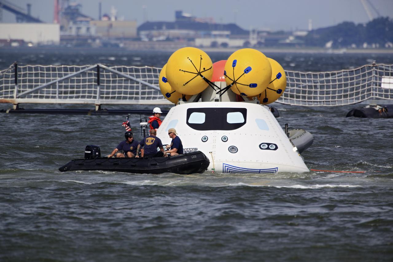 HAMPTON, Va. – At the Naval Station Norfolk near NASA’s Langley Research Center in Virginia, U.S. Navy personnel detach tether lines from the Orion boilerplate test article during a stationary recovery test in the water. NASA and the U.S. Navy are conducting tests to prepare for recovery of the Orion crew module and forward bay cover on its return from a deep space mission. The stationary recovery test will allow the teams to demonstrate and evaluate the recovery processes, procedures, hardware and personnel in a controlled environment before conducting a second recovery test next year in open waters. Orion is the exploration spacecraft designed to carry astronauts to destinations not yet explored by humans, including an asteroid and Mars. It will have emergency abort capability, sustain the crew during space travel and provide safe re-entry from deep space return velocities. The first unpiloted test flight of the Orion is scheduled to launch in 2014 atop a Delta IV rocket and in 2017 on NASA’s Space Launch System rocket. For more information, visit http://www.nasa.gov/orion. Photo credit: NASA/Dimitri Gerondidakis