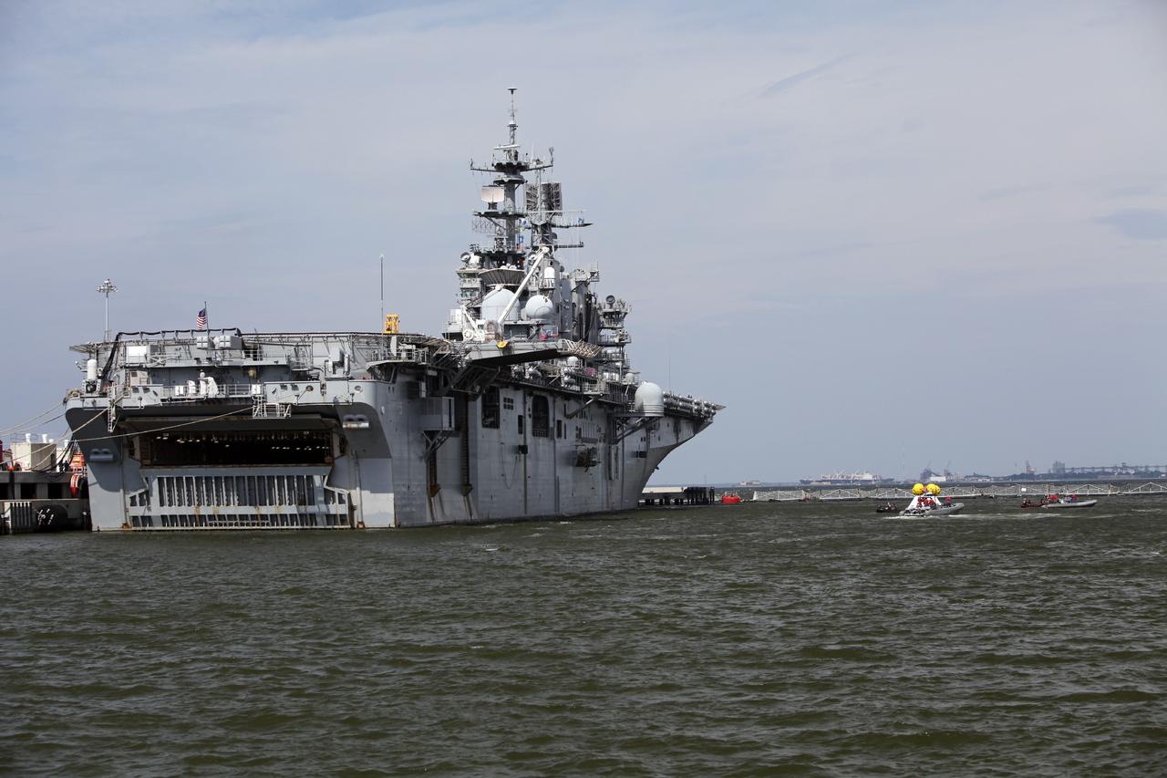 HAMPTON, Va. – At the Naval Station Norfolk near NASA’s Langley Research Center in Virginia, the Orion boilerplate test article floats in the water near a U.S. Navy ship during a stationary recovery test. NASA and the U.S. Navy are conducting tests to prepare for recovery of the Orion crew module and forward bay cover on its return from a deep space mission. The stationary recovery test will allow the teams to demonstrate and evaluate the recovery processes, procedures, hardware and personnel in a controlled environment before conducting a second recovery test next year in open waters. Orion is the exploration spacecraft designed to carry astronauts to destinations not yet explored by humans, including an asteroid and Mars. It will have emergency abort capability, sustain the crew during space travel and provide safe re-entry from deep space return velocities. The first unpiloted test flight of the Orion is scheduled to launch in 2014 atop a Delta IV rocket and in 2017 on NASA’s Space Launch System rocket. For more information, visit http://www.nasa.gov/orion. Photo credit: NASA/Dimitri Gerondidakis