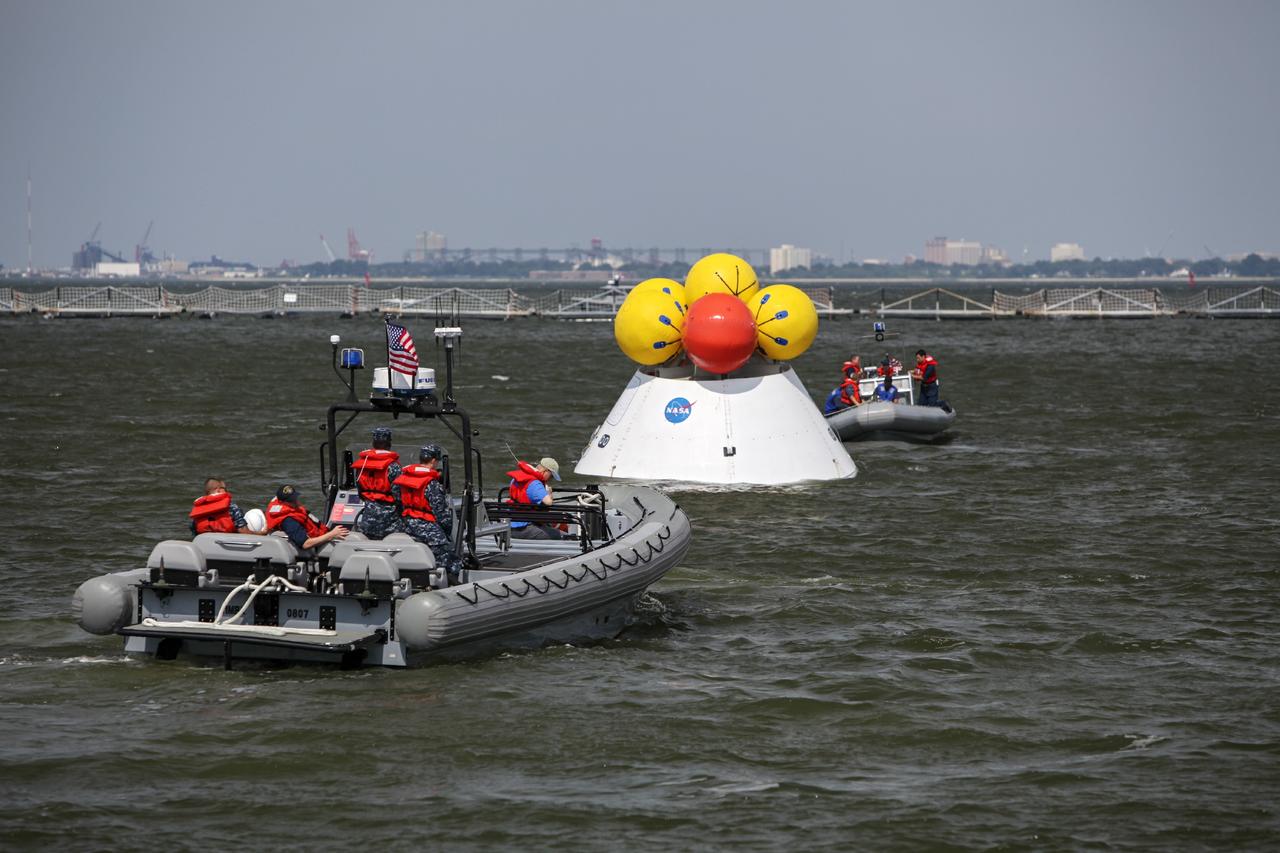 HAMPTON, Va. – At the Naval Station Norfolk near NASA’s Langley Research Center in Virginia, U.S. Navy personnel practice procedures during a stationary recovery test using the Orion boilerplate test article. NASA and the U.S. Navy are conducting tests to prepare for recovery of the Orion crew module and forward bay cover on its return from a deep space mission. The stationary recovery test will allow the teams to demonstrate and evaluate the recovery processes, procedures, hardware and personnel in a controlled environment before conducting a second recovery test next year in open waters. Orion is the exploration spacecraft designed to carry astronauts to destinations not yet explored by humans, including an asteroid and Mars. It will have emergency abort capability, sustain the crew during space travel and provide safe re-entry from deep space return velocities. The first unpiloted test flight of the Orion is scheduled to launch in 2014 atop a Delta IV rocket and in 2017 on NASA’s Space Launch System rocket. For more information, visit http://www.nasa.gov/orion. Photo credit: NASA/Dimitri Gerondidakis