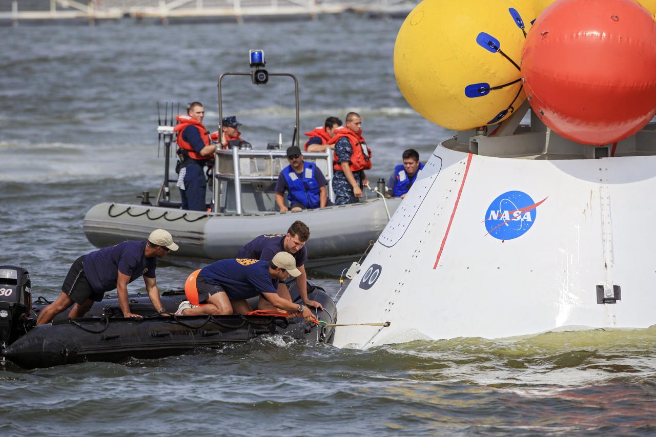 HAMPTON, Va. – At the Naval Station Norfolk near NASA’s Langley Research Center in Virginia, NASA and U.S. Navy personnel practice procedures during a stationary recovery test on the Orion boilerplate test article. NASA and the U.S. Navy are conducting tests to prepare for recovery of the Orion crew module and forward bay cover on its return from a deep space mission. The stationary recovery test will allow the teams to demonstrate and evaluate the recovery processes, procedures, hardware and personnel in a controlled environment before conducting a second recovery test next year in open waters. Orion is the exploration spacecraft designed to carry astronauts to destinations not yet explored by humans, including an asteroid and Mars. It will have emergency abort capability, sustain the crew during space travel and provide safe re-entry from deep space return velocities. The first unpiloted test flight of the Orion is scheduled to launch in 2014 atop a Delta IV rocket and in 2017 on NASA’s Space Launch System rocket. For more information, visit http://www.nasa.gov/orion. Photo credit: NASA/Dimitri Gerondidakis