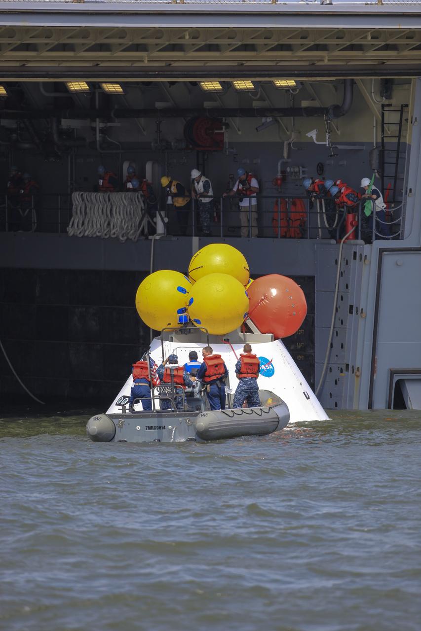 HAMPTON, Va. – At the Naval Station Norfolk near NASA’s Langley Research Center in Virginia, the Orion boilerplate test article is being returned to a U.S. Navy ship following a stationary recovery test in the water. NASA and the U.S. Navy are conducting tests to prepare for recovery of the Orion crew module and forward bay cover on its return from a deep space mission. The stationary recovery test will allow the teams to demonstrate and evaluate the recovery processes, procedures, hardware and personnel in a controlled environment before conducting a second recovery test next year in open waters. Orion is the exploration spacecraft designed to carry astronauts to destinations not yet explored by humans, including an asteroid and Mars. It will have emergency abort capability, sustain the crew during space travel and provide safe re-entry from deep space return velocities. The first unpiloted test flight of the Orion is scheduled to launch in 2014 atop a Delta IV rocket and in 2017 on NASA’s Space Launch System rocket. For more information, visit http://www.nasa.gov/orion. Photo credit: NASA/Dimitri Gerondidakis