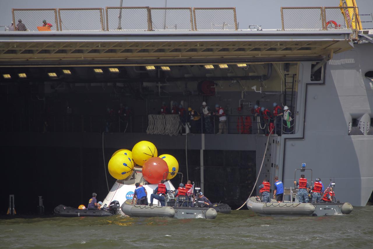 HAMPTON, Va. – At the Naval Station Norfolk near NASA’s Langley Research Center in Virginia, the Orion boilerplate test article is being returned to a U.S. Navy ship following a stationary recovery test in the water. NASA and the U.S. Navy are conducting tests to prepare for recovery of the Orion crew module and forward bay cover on its return from a deep space mission. The stationary recovery test will allow the teams to demonstrate and evaluate the recovery processes, procedures, hardware and personnel in a controlled environment before conducting a second recovery test next year in open waters. Orion is the exploration spacecraft designed to carry astronauts to destinations not yet explored by humans, including an asteroid and Mars. It will have emergency abort capability, sustain the crew during space travel and provide safe re-entry from deep space return velocities. The first unpiloted test flight of the Orion is scheduled to launch in 2014 atop a Delta IV rocket and in 2017 on NASA’s Space Launch System rocket. For more information, visit http://www.nasa.gov/orion. Photo credit: NASA/Dimitri Gerondidakis