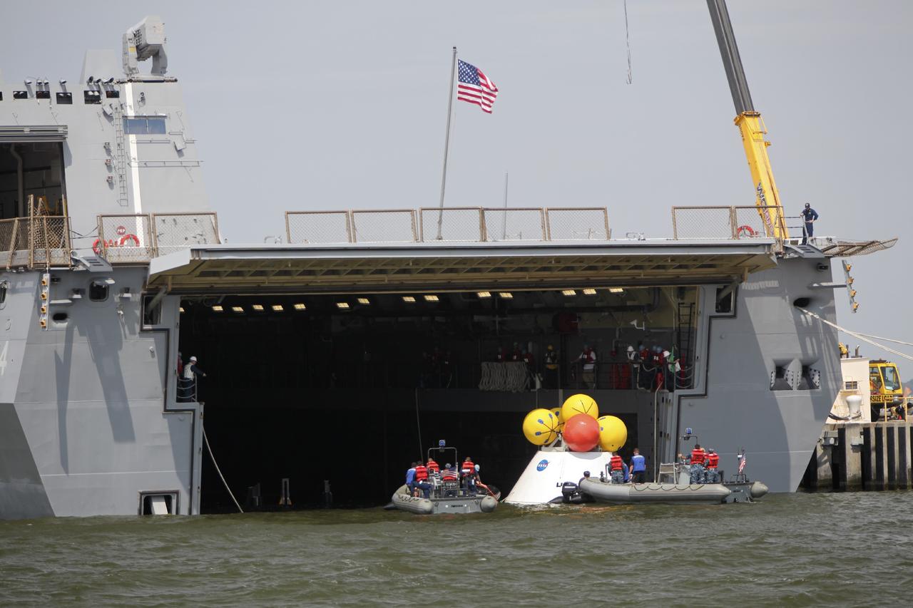 HAMPTON, Va. – At the Naval Station Norfolk near NASA’s Langley Research Center in Virginia, the Orion boilerplate test article is being returned to a U.S. Navy ship following a stationary recovery test in the water. NASA and the U.S. Navy are conducting tests to prepare for recovery of the Orion crew module and forward bay cover on its return from a deep space mission. The stationary recovery test will allow the teams to demonstrate and evaluate the recovery processes, procedures, hardware and personnel in a controlled environment before conducting a second recovery test next year in open waters. Orion is the exploration spacecraft designed to carry astronauts to destinations not yet explored by humans, including an asteroid and Mars. It will have emergency abort capability, sustain the crew during space travel and provide safe re-entry from deep space return velocities. The first unpiloted test flight of the Orion is scheduled to launch in 2014 atop a Delta IV rocket and in 2017 on NASA’s Space Launch System rocket. For more information, visit http://www.nasa.gov/orion. Photo credit: NASA/Dimitri Gerondidakis