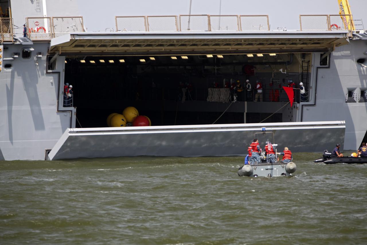 HAMPTON, Va. – At the Naval Station Norfolk near NASA’s Langley Research Center in Virginia, the Orion boilerplate test article has been returned to a U.S. Navy ship following a stationary recovery test in the water. NASA and the U.S. Navy are conducting tests to prepare for recovery of the Orion crew module and forward bay cover on its return from a deep space mission. The stationary recovery test will allow the teams to demonstrate and evaluate the recovery processes, procedures, hardware and personnel in a controlled environment before conducting a second recovery test next year in open waters. Orion is the exploration spacecraft designed to carry astronauts to destinations not yet explored by humans, including an asteroid and Mars. It will have emergency abort capability, sustain the crew during space travel and provide safe re-entry from deep space return velocities. The first unpiloted test flight of the Orion is scheduled to launch in 2014 atop a Delta IV rocket and in 2017 on NASA’s Space Launch System rocket. For more information, visit http://www.nasa.gov/orion. Photo credit: NASA/Dimitri Gerondidakis