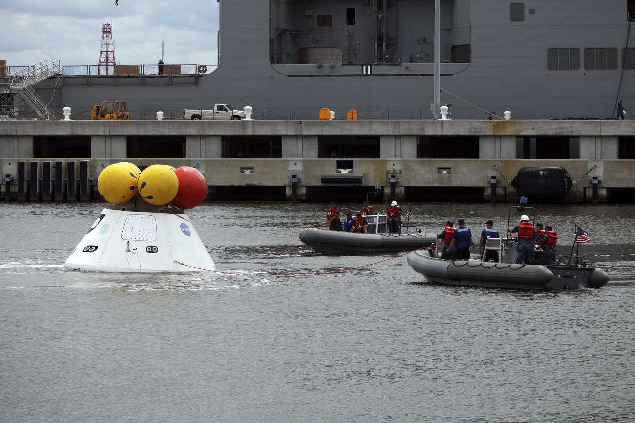 HAMPTON, Va. – At the Naval Station Norfolk near NASA’s Langley Research Center in Virginia, NASA and the U.S. Navy are conducting a stationary recovery test on the Orion boilerplate test article in the water near a U.S. Navy ship. NASA and the U.S. Navy are conducting tests to prepare for recovery of the Orion crew module and forward bay cover on its return from a deep space mission. The stationary recovery test will allow the teams to demonstrate and evaluate the recovery processes, procedures, hardware and personnel in a controlled environment before conducting a second recovery test next year in open waters. Orion is the exploration spacecraft designed to carry astronauts to destinations not yet explored by humans, including an asteroid and Mars. It will have emergency abort capability, sustain the crew during space travel and provide safe re-entry from deep space return velocities. The first unpiloted test flight of the Orion is scheduled to launch in 2014 atop a Delta IV rocket and in 2017 on NASA’s Space Launch System rocket. For more information, visit http://www.nasa.gov/orion. Photo credit: NASA/Dimitri Gerondidakis