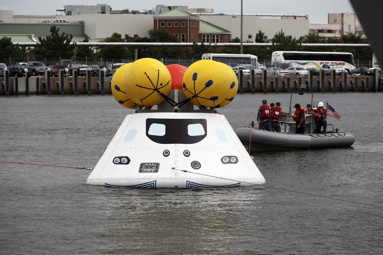 HAMPTON, Va. – At the Naval Station Norfolk near NASA’s Langley Research Center in Virginia, NASA and the U.S. Navy are conducting a stationary recovery test on the Orion boilerplate test article in the water near a U.S. Navy ship. NASA and the U.S. Navy are conducting tests to prepare for recovery of the Orion crew module and forward bay cover on its return from a deep space mission. The stationary recovery test will allow the teams to demonstrate and evaluate the recovery processes, procedures, hardware and personnel in a controlled environment before conducting a second recovery test next year in open waters. Orion is the exploration spacecraft designed to carry astronauts to destinations not yet explored by humans, including an asteroid and Mars. It will have emergency abort capability, sustain the crew during space travel and provide safe re-entry from deep space return velocities. The first unpiloted test flight of the Orion is scheduled to launch in 2014 atop a Delta IV rocket and in 2017 on NASA’s Space Launch System rocket. For more information, visit http://www.nasa.gov/orion. Photo credit: NASA/Dimitri Gerondidakis