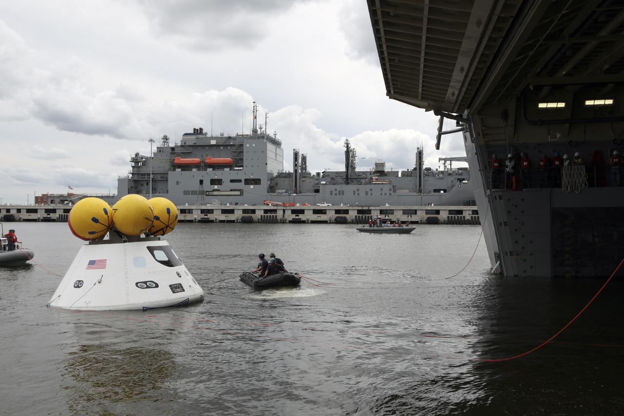 HAMPTON, Va. – At the Naval Station Norfolk near NASA’s Langley Research Center in Virginia, NASA and the U.S. Navy are conducting a stationary recovery test on the Orion boilerplate test article in the water near a U.S. Navy ship. NASA and the U.S. Navy are conducting tests to prepare for recovery of the Orion crew module and forward bay cover on its return from a deep space mission. The stationary recovery test will allow the teams to demonstrate and evaluate the recovery processes, procedures, hardware and personnel in a controlled environment before conducting a second recovery test next year in open waters. Orion is the exploration spacecraft designed to carry astronauts to destinations not yet explored by humans, including an asteroid and Mars. It will have emergency abort capability, sustain the crew during space travel and provide safe re-entry from deep space return velocities. The first unpiloted test flight of the Orion is scheduled to launch in 2014 atop a Delta IV rocket and in 2017 on NASA’s Space Launch System rocket. For more information, visit http://www.nasa.gov/orion. Photo credit: NASA/Dimitri Gerondidakis