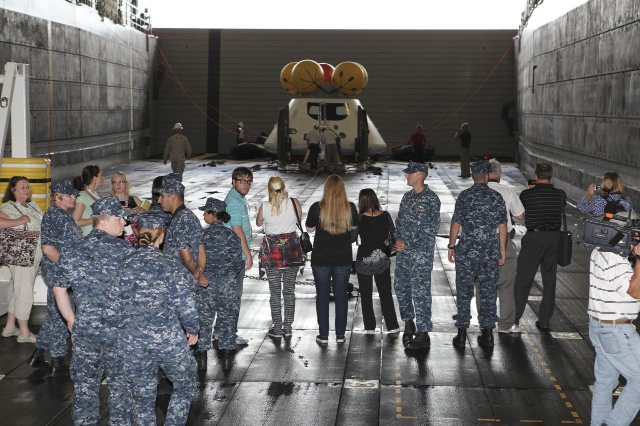 HAMPTON, Va. – At the Naval Station Norfolk near NASA’s Langley Research Center in Virginia, members of the media observe the Orion boilerplate test article and support equipment for a stationary recovery test secured in a U.S. Navy ship. NASA and the U.S. Navy are conducting tests to prepare for recovery of the Orion crew module and forward bay cover on its return from a deep space mission. The stationary recovery test will allow the teams to demonstrate and evaluate the recovery processes, procedures, hardware and personnel in a controlled environment before conducting a second recovery test next year in open waters. Orion is the exploration spacecraft designed to carry astronauts to destinations not yet explored by humans, including an asteroid and Mars. It will have emergency abort capability, sustain the crew during space travel and provide safe re-entry from deep space return velocities. The first unpiloted test flight of the Orion is scheduled to launch in 2014 atop a Delta IV rocket and in 2017 on NASA’s Space Launch System rocket. For more information, visit http://www.nasa.gov/orion. Photo credit: NASA/Dimitri Gerondidakis