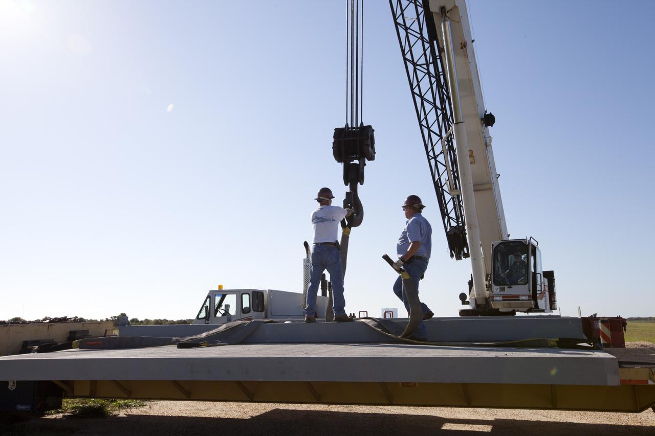 CAPE CANAVERAL, Fla. - At NASA’s Kennedy Space Center in Florida, workers enlist a crane to load the movable launch platform for the Project Morpheus lander onto a flatbed truck for its move from the midfield to the north end of the Shuttle Landing Facility, or SLF.      Testing of the prototype lander has been ongoing at NASA’s Johnson Space Center in Houston in preparation for free flight. The lander is scheduled for delivery to Kennedy in October. The SLF will provide the lander with the kind of field necessary for realistic testing, complete with rocks, craters and hazards to avoid. Morpheus utilizes an autonomous landing and hazard avoidance technology, or ALHAT, payload that will allow it to navigate to clear landing sites amidst obstacles during its descent. Project Morpheus is one of 20 small projects comprising the Advanced Exploration Systems, or AES, program in NASA’s Human Exploration and Operations Mission Directorate. AES projects pioneer new approaches for rapidly developing prototype systems, demonstrating key capabilities and validating operational concepts for future human missions beyond Earth orbit. For more information on Project Morpheus, visit http://www.nasa.gov/centers/johnson/exploration/morpheus/index.html. Photo credit: NASA/Kim Shiflett