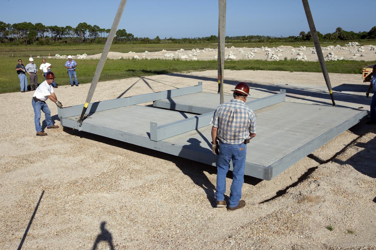 CAPE CANAVERAL, Fla. - At NASA’s Kennedy Space Center in Florida, workers lower the movable launch platform for the Project Morpheus lander onto its new site adjacent to a hazard field created to support the project at the north end of the Shuttle Landing Facility, or SLF.      Testing of the prototype lander has been ongoing at NASA’s Johnson Space Center in Houston in preparation for free flight. The lander is scheduled for delivery to Kennedy in October. The SLF will provide the lander with the kind of field necessary for realistic testing, complete with rocks, craters and hazards to avoid. Morpheus utilizes an autonomous landing and hazard avoidance technology, or ALHAT, payload that will allow it to navigate to clear landing sites amidst obstacles during its descent. Project Morpheus is one of 20 small projects comprising the Advanced Exploration Systems, or AES, program in NASA’s Human Exploration and Operations Mission Directorate. AES projects pioneer new approaches for rapidly developing prototype systems, demonstrating key capabilities and validating operational concepts for future human missions beyond Earth orbit. For more information on Project Morpheus, visit http://www.nasa.gov/centers/johnson/exploration/morpheus/index.html. Photo credit: NASA/Kim Shiflett