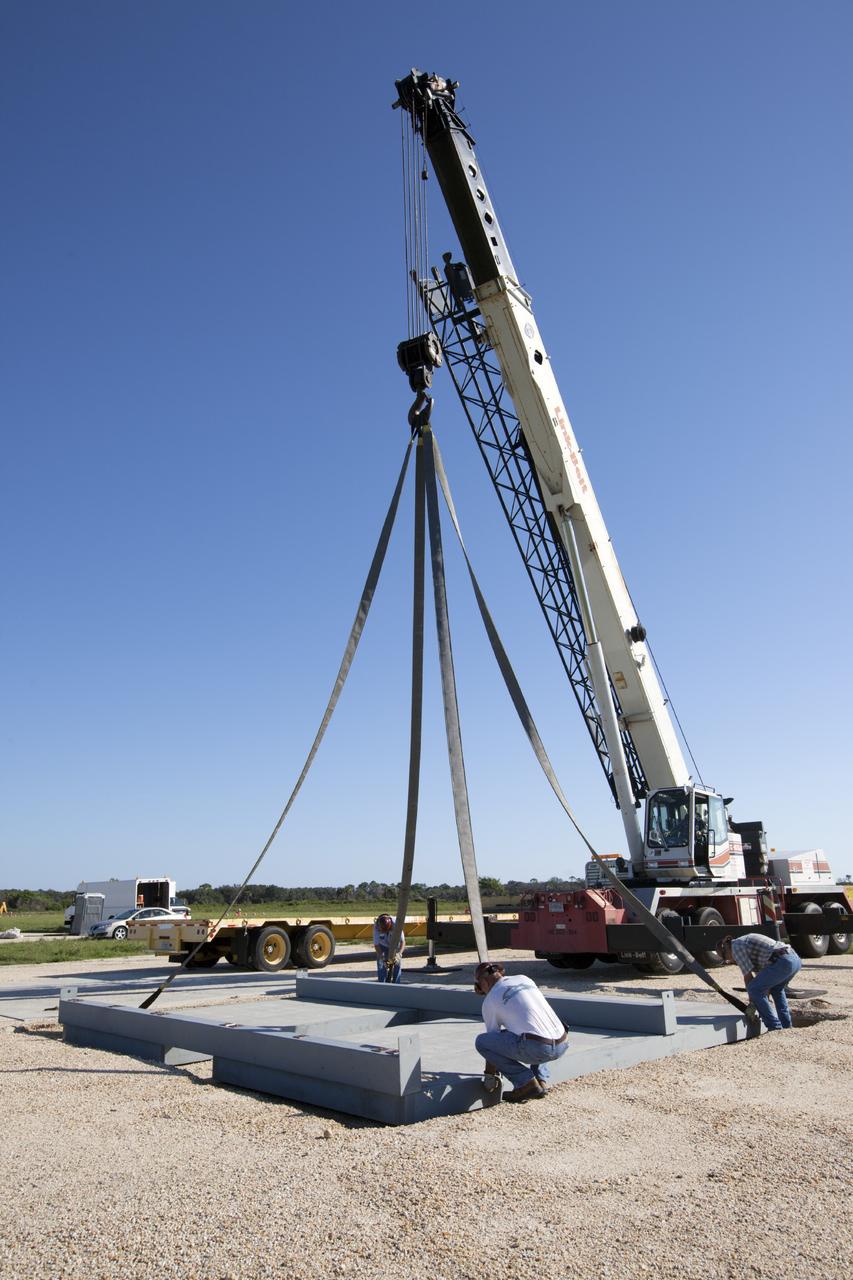 CAPE CANAVERAL, Fla. - At NASA’s Kennedy Space Center in Florida, workers release the movable launch platform for the Project Morpheus lander from the crane used to position it on its new site adjacent to a hazard field created to support the project at the north end of the Shuttle Landing Facility, or SLF.       Testing of the prototype lander has been ongoing at NASA’s Johnson Space Center in Houston in preparation for free flight. The lander is scheduled for delivery to Kennedy in October. The SLF will provide the lander with the kind of field necessary for realistic testing, complete with rocks, craters and hazards to avoid. Morpheus utilizes an autonomous landing and hazard avoidance technology, or ALHAT, payload that will allow it to navigate to clear landing sites amidst obstacles during its descent. Project Morpheus is one of 20 small projects comprising the Advanced Exploration Systems, or AES, program in NASA’s Human Exploration and Operations Mission Directorate. AES projects pioneer new approaches for rapidly developing prototype systems, demonstrating key capabilities and validating operational concepts for future human missions beyond Earth orbit. For more information on Project Morpheus, visit http://www.nasa.gov/centers/johnson/exploration/morpheus/index.html. Photo credit: NASA/Kim Shiflett