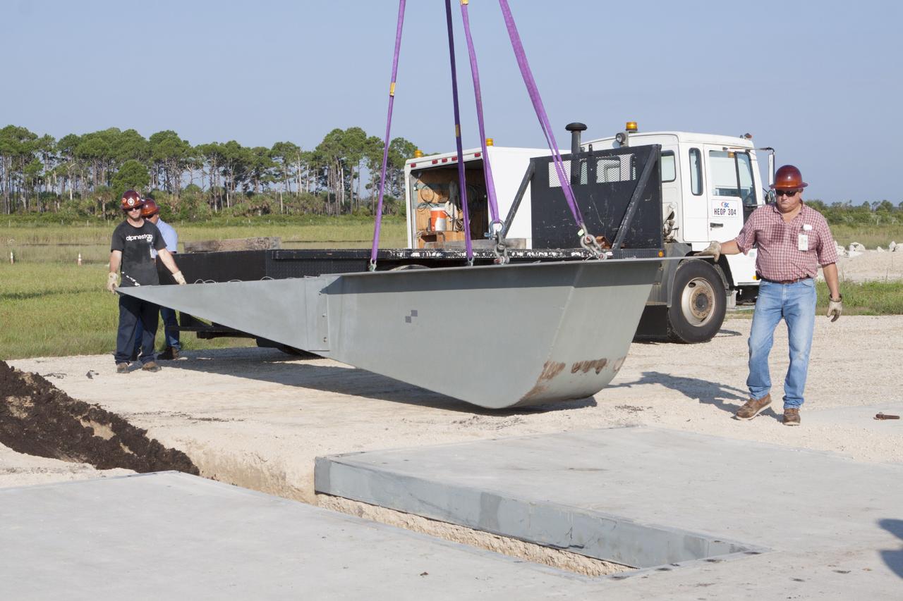 CAPE CANAVERAL, Fla. - Workers install a flame deflector at the Shuttle Landing Facility, or SLF, at NASA's Kennedy Space Center in Florida for the Project Morpheus lander. The site is adjacent to a hazard field created to support the project at the north end of the SLF. Testing of the prototype lander has been ongoing at NASA’s Johnson Space Center in Houston in preparation for a free flight at Kennedy later this year. The SLF will provide the lander with the kind of field necessary for realistic testing, complete with rocks, craters and hazards to avoid.         Morpheus utilizes an autonomous landing and hazard avoidance technology, or ALHAT, payload that will allow it to navigate to clear landing sites amidst obstacles during its descent. Project Morpheus is one of 20 small projects comprising the Advanced Exploration Systems, or AES, program in NASA’s Human Exploration and Operations Mission Directorate. AES projects pioneer new approaches for rapidly developing prototype systems, demonstrating key capabilities and validating operational concepts for future human missions beyond Earth orbit. For more information on Project Morpheus, visit http://www.nasa.gov/centers/johnson/exploration/morpheus/index.html. Photo credit: NASA/Kim Shiflett