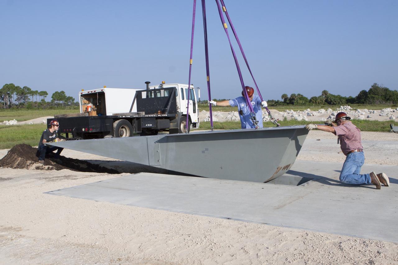 CAPE CANAVERAL, Fla. - Workers install a flame deflector at the Shuttle Landing Facility, or SLF, at NASA's Kennedy Space Center in Florida for the Project Morpheus lander. The site is adjacent to a hazard field created to support the project at the north end of the SLF. Testing of the prototype lander has been ongoing at NASA’s Johnson Space Center in Houston in preparation for a free flight at Kennedy later this year. The SLF will provide the lander with the kind of field necessary for realistic testing, complete with rocks, craters and hazards to avoid.         Morpheus utilizes an autonomous landing and hazard avoidance technology, or ALHAT, payload that will allow it to navigate to clear landing sites amidst obstacles during its descent. Project Morpheus is one of 20 small projects comprising the Advanced Exploration Systems, or AES, program in NASA’s Human Exploration and Operations Mission Directorate. AES projects pioneer new approaches for rapidly developing prototype systems, demonstrating key capabilities and validating operational concepts for future human missions beyond Earth orbit. For more information on Project Morpheus, visit http://www.nasa.gov/centers/johnson/exploration/morpheus/index.html. Photo credit: NASA/Kim Shiflett