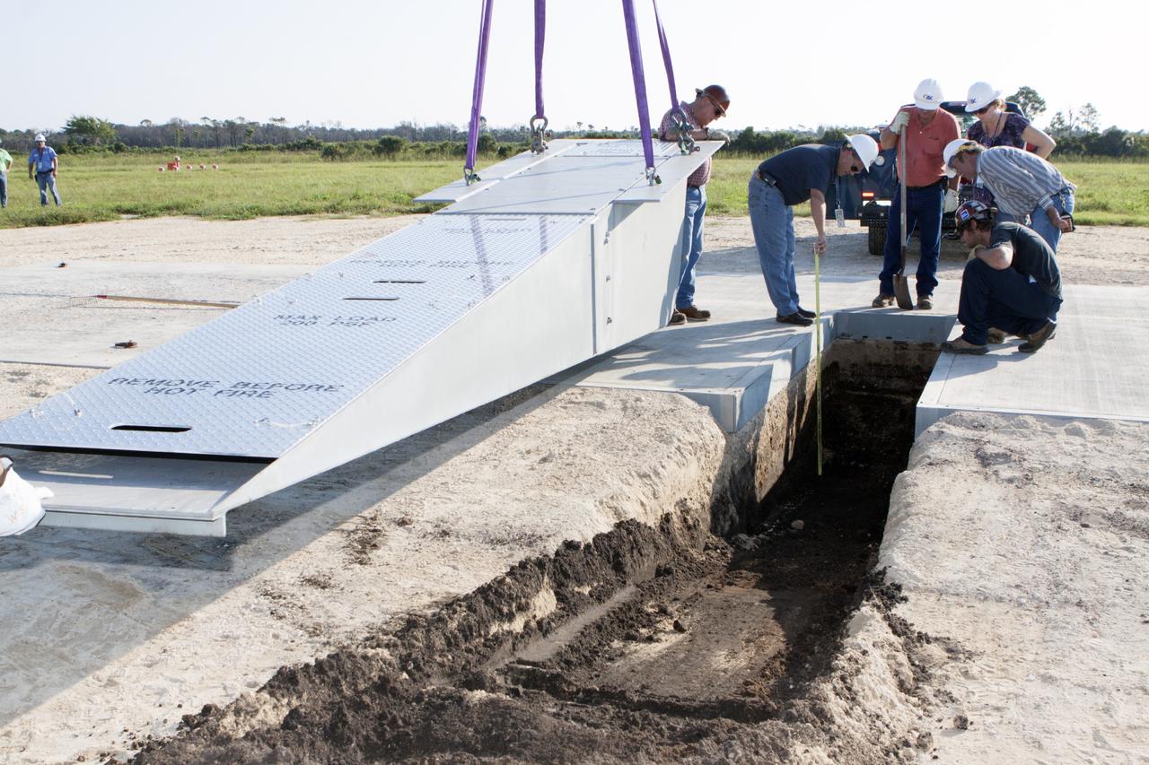 CAPE CANAVERAL, Fla. - Workers install a flame deflector at the Shuttle Landing Facility, or SLF, at NASA's Kennedy Space Center in Florida for the Project Morpheus lander. The site is adjacent to a hazard field created to support the project at the north end of the SLF. Testing of the prototype lander has been ongoing at NASA’s Johnson Space Center in Houston in preparation for a free flight at Kennedy later this year. The SLF will provide the lander with the kind of field necessary for realistic testing, complete with rocks, craters and hazards to avoid.         Morpheus utilizes an autonomous landing and hazard avoidance technology, or ALHAT, payload that will allow it to navigate to clear landing sites amidst obstacles during its descent. Project Morpheus is one of 20 small projects comprising the Advanced Exploration Systems, or AES, program in NASA’s Human Exploration and Operations Mission Directorate. AES projects pioneer new approaches for rapidly developing prototype systems, demonstrating key capabilities and validating operational concepts for future human missions beyond Earth orbit. For more information on Project Morpheus, visit http://www.nasa.gov/centers/johnson/exploration/morpheus/index.html. Photo credit: NASA/Kim Shiflett