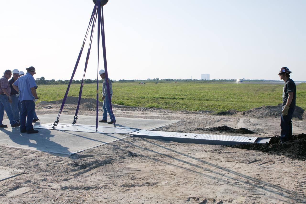 CAPE CANAVERAL, Fla. - Workers install a flame deflector at the Shuttle Landing Facility, or SLF, at NASA's Kennedy Space Center in Florida for the Project Morpheus lander. The site is adjacent to a hazard field created to support the project at the north end of the SLF. Testing of the prototype lander has been ongoing at NASA’s Johnson Space Center in Houston in preparation for a free flight at Kennedy later this year. The SLF will provide the lander with the kind of field necessary for realistic testing, complete with rocks, craters and hazards to avoid.         Morpheus utilizes an autonomous landing and hazard avoidance technology, or ALHAT, payload that will allow it to navigate to clear landing sites amidst obstacles during its descent. Project Morpheus is one of 20 small projects comprising the Advanced Exploration Systems, or AES, program in NASA’s Human Exploration and Operations Mission Directorate. AES projects pioneer new approaches for rapidly developing prototype systems, demonstrating key capabilities and validating operational concepts for future human missions beyond Earth orbit. For more information on Project Morpheus, visit http://www.nasa.gov/centers/johnson/exploration/morpheus/index.html. Photo credit: NASA/Kim Shiflett