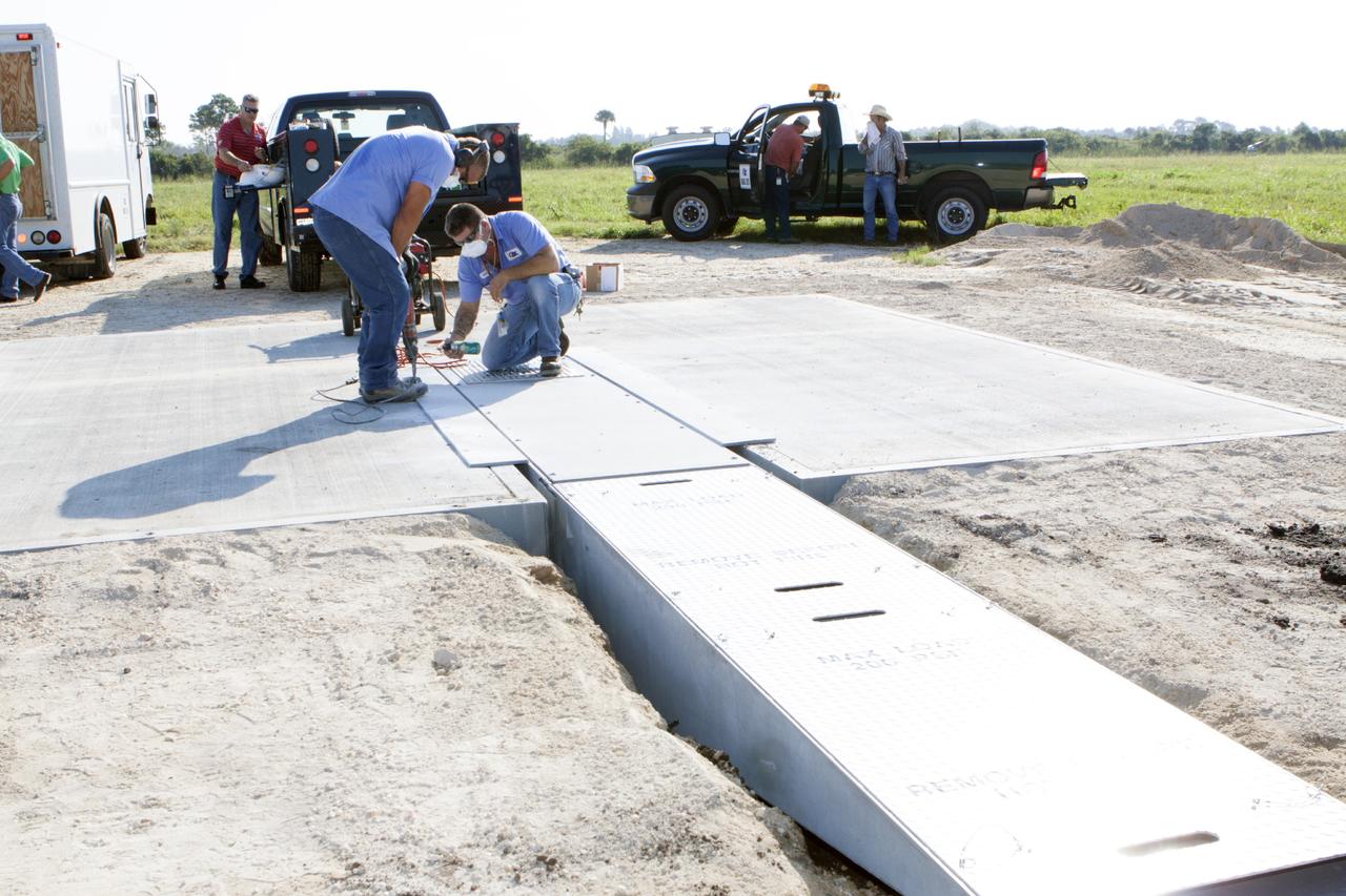 CAPE CANAVERAL, Fla. - Workers install a flame deflector at the Shuttle Landing Facility, or SLF, at NASA's Kennedy Space Center in Florida for the Project Morpheus lander. The site is adjacent to a hazard field created to support the project at the north end of the SLF. Testing of the prototype lander has been ongoing at NASA’s Johnson Space Center in Houston in preparation for a free flight at Kennedy later this year. The SLF will provide the lander with the kind of field necessary for realistic testing, complete with rocks, craters and hazards to avoid.         Morpheus utilizes an autonomous landing and hazard avoidance technology, or ALHAT, payload that will allow it to navigate to clear landing sites amidst obstacles during its descent. Project Morpheus is one of 20 small projects comprising the Advanced Exploration Systems, or AES, program in NASA’s Human Exploration and Operations Mission Directorate. AES projects pioneer new approaches for rapidly developing prototype systems, demonstrating key capabilities and validating operational concepts for future human missions beyond Earth orbit. For more information on Project Morpheus, visit http://www.nasa.gov/centers/johnson/exploration/morpheus/index.html. Photo credit: NASA/Kim Shiflett