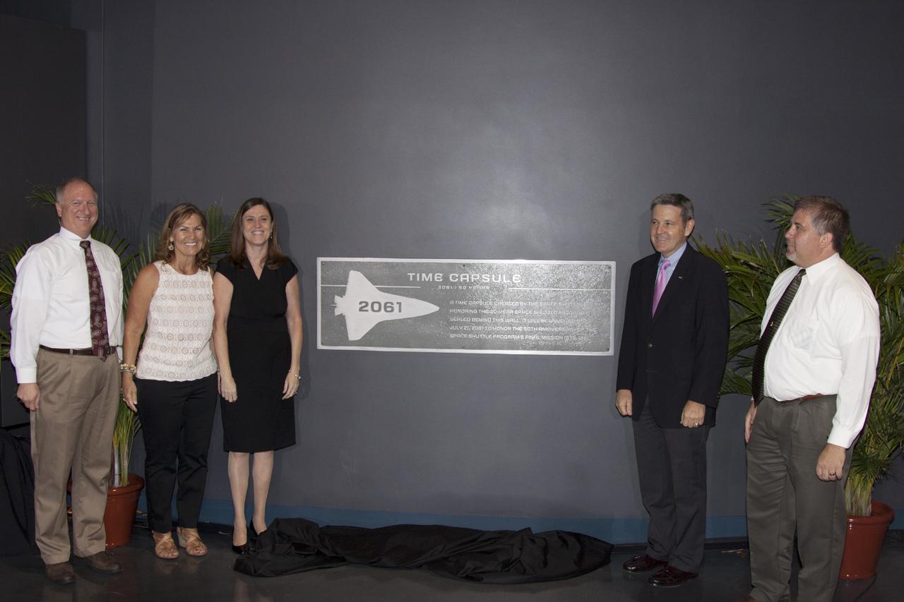 CAPE CANAVERAL, Fla. -- At the Kennedy Space Center Visitor Complex in Florida, officials pose at the site where a Shuttle Program time capsule has been secured vault within the walls of the Space Shuttle Atlantis home at the Kennedy Space Center Visitor Complex. From the left are: Pete Nickolenko, deputy director of NASA Ground Processing at Kennedy, Patty Stratton of Abacus Technology, currently program manager for the Information Management Communications Support Contract. During the Shuttle Program she was deputy director of Ground Operations for NASA's Space Program Operations Contractor, United Space Alliance, Rita Wilcoxon, NASA's now retired director of Shuttle Processing, Bob Cabana, director of the Kennedy Space Center and George Jacobs, deputy director of Center Operations, who was manager of the agency's Shuttle Transition and Retirement Project Office.      The time capsule, containing artifacts and other memorabilia associated with the history of the program is designated to be opened on the 50th anniversary of the shuttle's final landing, STS-135. The new $100 million "Space Shuttle Atlantis" facility includes interactive exhibits that tell the story of the 30-year Space Shuttle Program and highlight the future of space exploration. Photo credit: NASA/Jim Grossmann