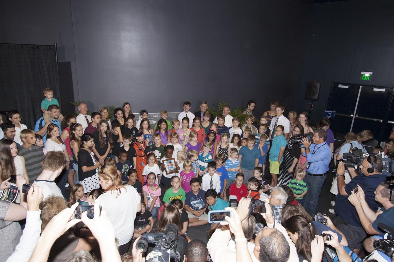 CAPE CANAVERAL, Fla. -- At the Kennedy Space Center Visitor Complex in Florida, future space explorers gather during ceremonies to enshrine a Space Shuttle Program time capsule in a secured vault within the walls of the Space Shuttle Atlantis home at the Kennedy Space Center Visitor Complex. The time capsule, containing artifacts and other memorabilia associated with the history of the program is designated to be opened on the 50th anniversary of the shuttle's final landing, STS-135. The new $100 million "Space Shuttle Atlantis" facility includes interactive exhibits that tell the story of the 30-year Space Shuttle Program and highlight the future of space exploration. Photo credit: NASA/Jim Grossmann