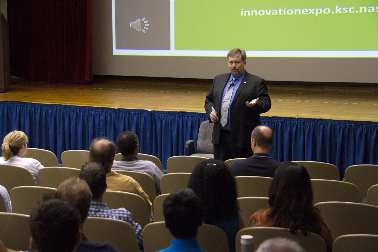 CAPE CANAVERAL, Fla. -- At NASA's Kennedy Space Center in Florida, NASA chief technologist Mason Peck addresses the audience in the KSC Training Auditorium at KSC Talks 2013 on the second day of the KSC Innovation Expo.     KSC Talks featured a series of speakers that collectively took the audience on a journey through innovation, from inspiration to application and beyond. The variety of topics presented encouraged the audience to become “Ready for Anything,” to learn how to “Train and un-train Your Brain for Innovation,” and to discover how to “Change the Possible,” among others.  Photo credit: NASA/Cory Huston