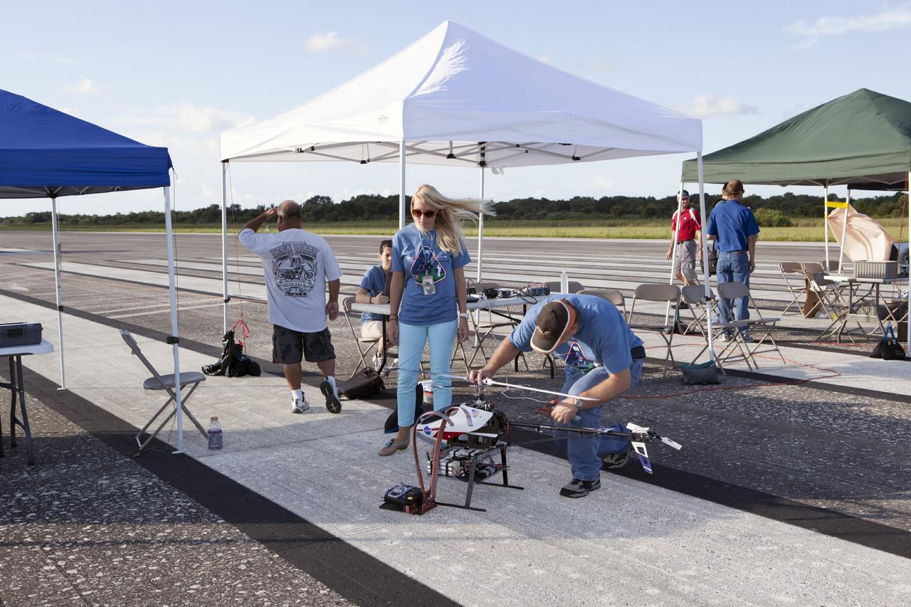 CAPE CANAVERAL, Fla. – Engineers fine-tune a remote-controlled helicopter before it takes off. The helicopter is equipped with a unique set of sensors and software and was assembled by a team of engineers from NASA's Johnson Space Center for a competition at the agency's Kennedy Space Center. Teams from Johnson, Kennedy and Marshall Space Flight Center competed in an unmanned aerial systems event to evaluate designs and work by engineers learning new specialties. The competition took place at the Shuttle Landing Facility at Kennedy. Photo credit: NASA/Dmitri Gerondidakis