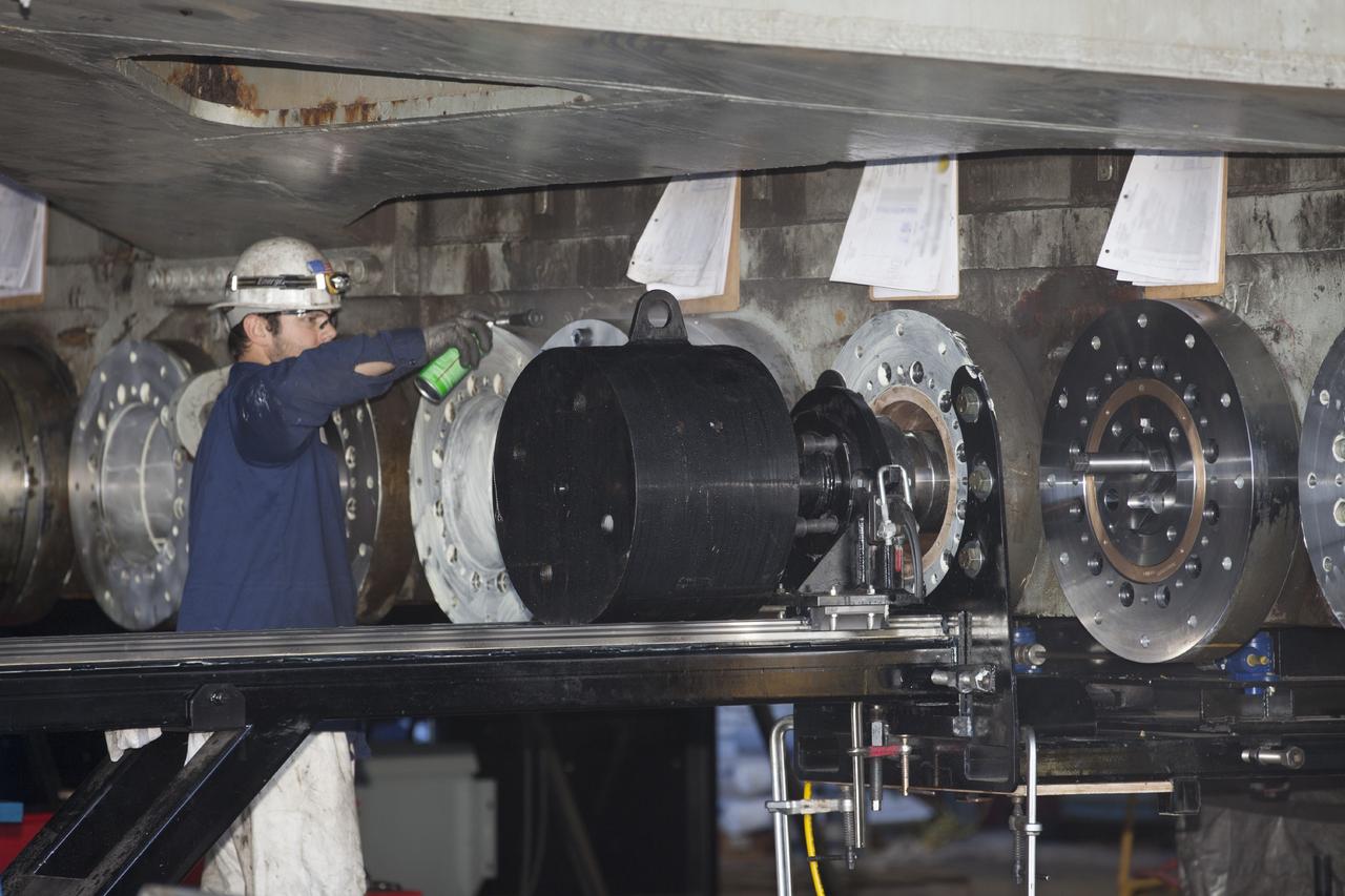 CAPE CANAVERAL, Fla. -- A technician completes the installation of a new bearing on crawler-transporter 2 in Vehicle Assembly Building High Bay 2 at NASA's Kennedy Space Center in Florida.      Modifications underway on the crawler are designed to ensure its ability to transport launch vehicles currently under development, such as the agency’s Space Launch System, to the launch pad. Present modifications represent a redesign and upgrade to the roller bearings and assemblies originally installed on the crawler. The Ground Systems Development and Operations Program office at Kennedy is overseeing the upgrades. For more than 45 years the crawler-transporters were used to transport the mobile launcher platform carrying the Apollo-Saturn V rockets and space shuttles to Launch Pads 39A and 39B. For more information, visit http://www.nasa.gov/exploration/systems/ground/crawler-transporter_bearings_prt.htm. Photo credit: NASA/Kim Shiflett