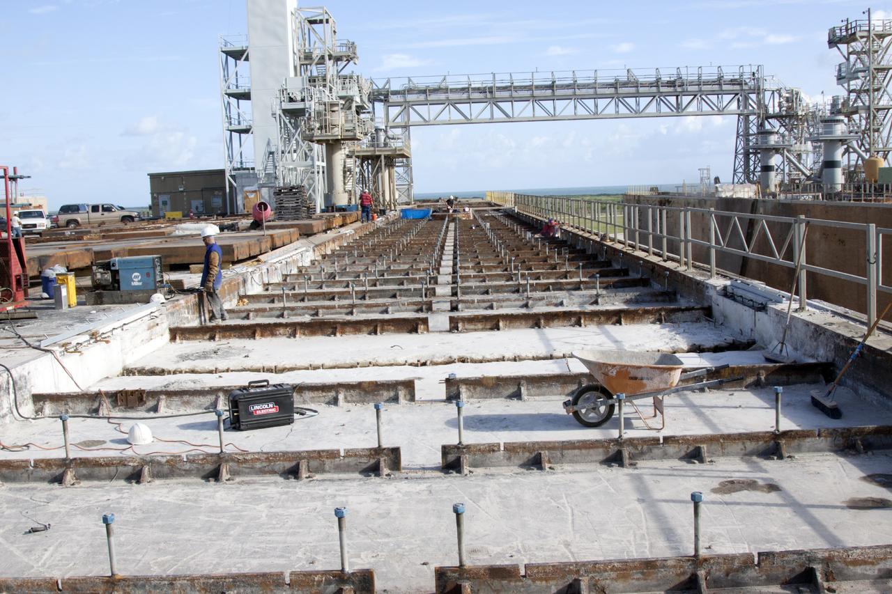 CAPE CANAVERAL, Fla. – At Launch Pad 39B at NASA’s Kennedy Space Center in Florida, the crawler track panels have been removed and construction workers continue to repair the concrete on the surface of the pad. The flame trench deflector that was located below and between the left and right crawlerway tracks has been removed.     Pad B is being refurbished to support NASA’s Space Launch System and other launch vehicles. The Ground Systems Development and Operations, or GSDO, Program at Kennedy is leading the center’s transformation to safely handle a variety of rockets and spacecraft. For more information about GSDO, visit: http://go.nasa.gov/groundsystems.  Photo credit: NASA/Jim Grossman