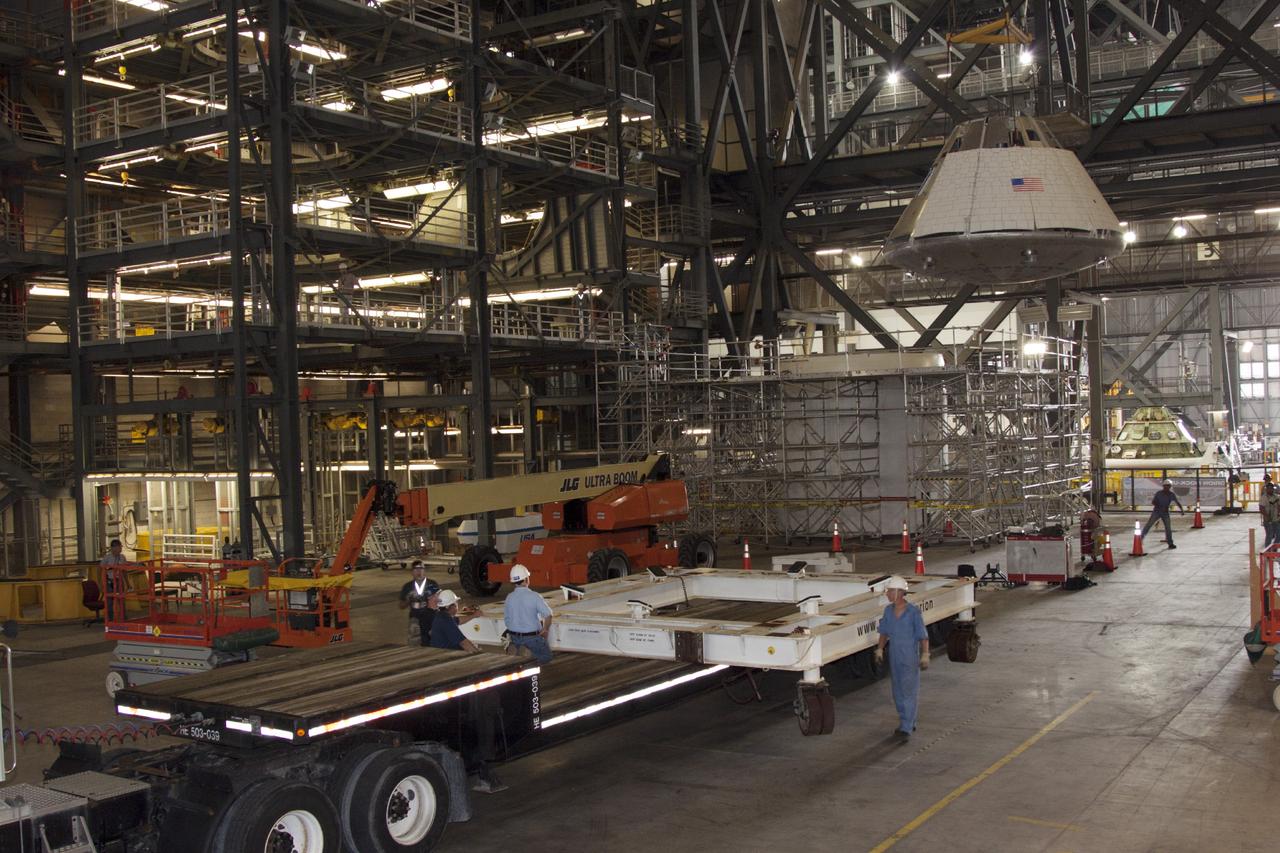 CAPE CANAVERAL, Fla. – Workers place a mock Orion capsule on a trailer during de-stacking operations in the Vehicle Assembly Building at NASA's Kennedy Space Center in Florida. The stack has been used to evaluate potential techniques to be used in assembling the Orion and service module for operational flights in the future. Photo credit: NASA/Jim Grossmann