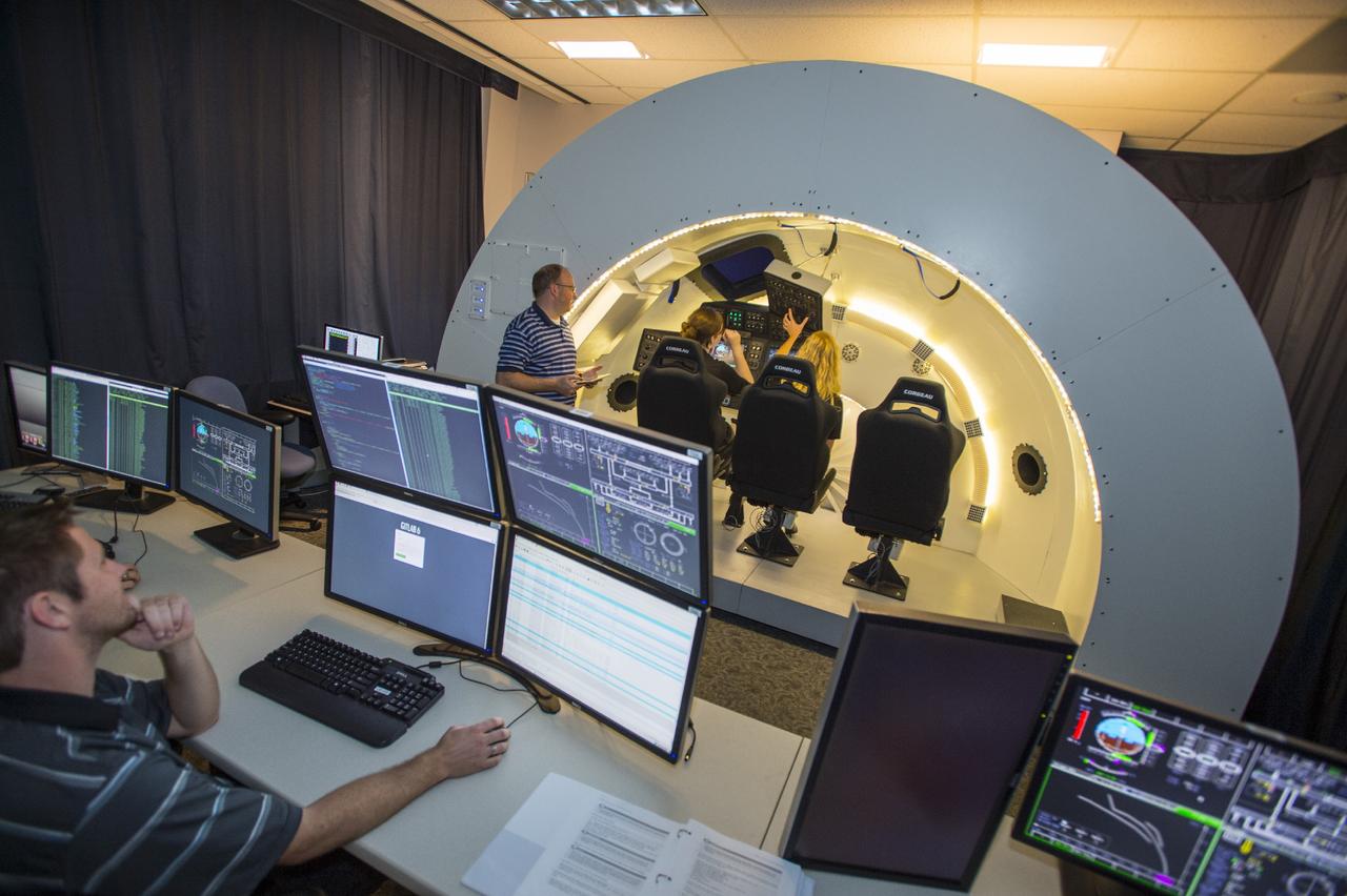 HOUSTON – Engineers and managers work inside a simulator of The Boeing Company's CST-100 spacecraft during evaluations of potential designs and software functions in a room at the company's Houston location. The CST-100 is under development in partnership between the company and NASA's Commercial Crew Program, or CCP. The spacecraft is designed to fly to low-Earth orbit and potentially dock with the International Space Station. Photo credit: The Boeing Company