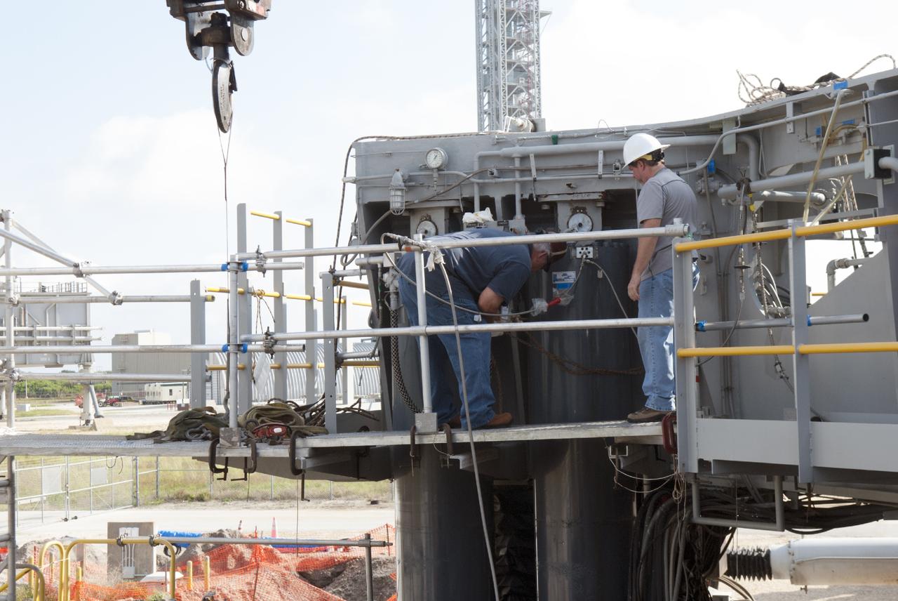 CAPE CANAVERAL, Fla. – Ground support equipment technicians prepare to remove the jacking, equalizing and leveling, or JEL, hydraulic cylinders from crawler-transporter 1 at the crawler transporter maintenance facility at NASA’s Kennedy Space Center in Florida. Sixteen new JEL hydraulic cylinders will be installed on CT-1 to increase load carrying capacity and reliability. The Ground Systems Development and Operations Program at Kennedy continues to upgrade CT-1 as part of its general maintenance. CT-1 could be available to carry commercial launch vehicles to the launch pad. The crawler-transporters were used to carry the mobile launcher platform and space shuttle to Launch Complex 39 for space shuttle launches for 30 years. Photo credit: NASA/Tim Jacobs