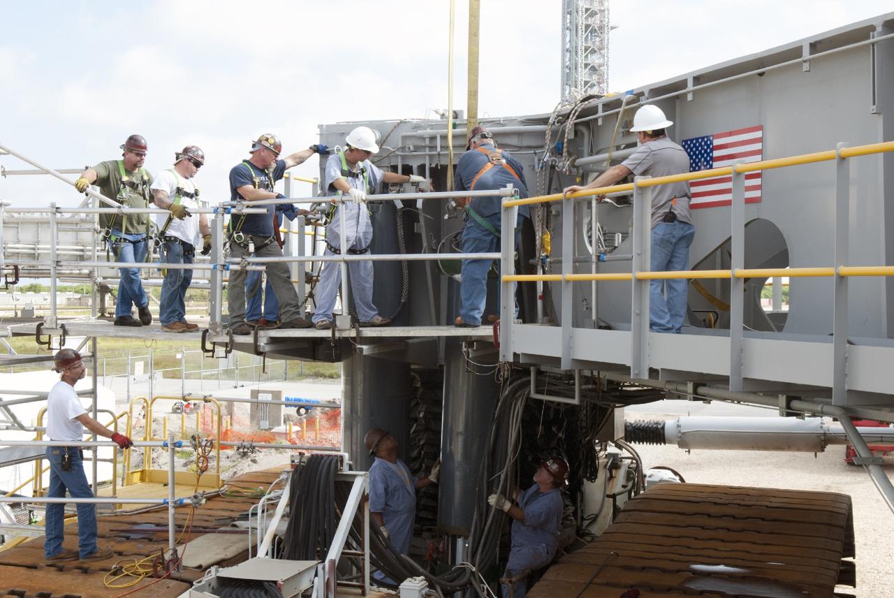 CAPE CANAVERAL, Fla. – Ground support equipment technicians prepare one of the jacking, equalizing and leveling, or JEL, hydraulic cylinders for removal from crawler-transporter 1 at the crawler transporter maintenance facility at NASA’s Kennedy Space Center in Florida. Sixteen new JEL hydraulic cylinders will be installed on CT-1 to increase load carrying capacity and reliability. The Ground Systems Development and Operations Program at Kennedy continues to upgrade CT-1 as part of its general maintenance. CT-1 could be available to carry commercial launch vehicles to the launch pad. The crawler-transporters were used to carry the mobile launcher platform and space shuttle to Launch Complex 39 for space shuttle launches for 30 years. Photo credit: NASA/Tim Jacobs