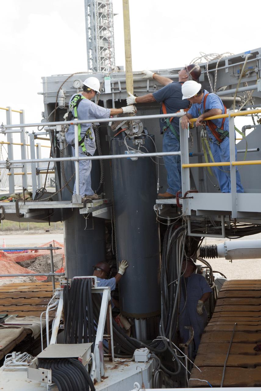 CAPE CANAVERAL, Fla. – Ground support equipment technicians prepare one of the jacking, equalizing and leveling, or JEL, hydraulic cylinders for removal from crawler-transporter 1 at the crawler transporter maintenance facility at NASA’s Kennedy Space Center in Florida. Sixteen new JEL hydraulic cylinders will be installed on CT-1 to increase load carrying capacity and reliability. The Ground Systems Development and Operations Program at Kennedy continues to upgrade CT-1 as part of its general maintenance. CT-1 could be available to carry commercial launch vehicles to the launch pad. The crawler-transporters were used to carry the mobile launcher platform and space shuttle to Launch Complex 39 for space shuttle launches for 30 years. Photo credit: NASA/Tim Jacobs
