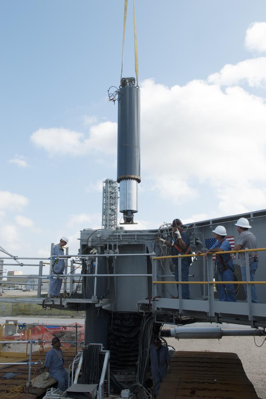 CAPE CANAVERAL, Fla. – Ground support equipment technicians monitor the progress as one of the jacking, equalizing and leveling, or JEL, hydraulic cylinders is lifted from crawler-transporter 1 at the crawler transporter maintenance facility at NASA’s Kennedy Space Center in Florida. Sixteen new JEL hydraulic cylinders will be installed on CT-1 to increase load carrying capacity and reliability. The Ground Systems Development and Operations Program at Kennedy continues to upgrade CT-1 as part of its general maintenance. CT-1 could be available to carry commercial launch vehicles to the launch pad. The crawler-transporters were used to carry the mobile launcher platform and space shuttle to Launch Complex 39 for space shuttle launches for 30 years. Photo credit: NASA/Tim Jacobs