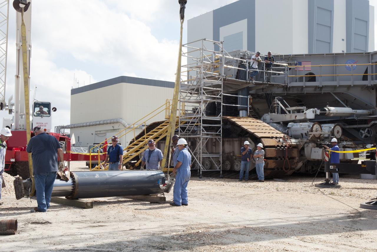 CAPE CANAVERAL, Fla. – Ground support equipment technicians assist as one of the jacking, equalizing and leveling, or JEL, hydraulic cylinders is lowered to the ground after it was removed from crawler-transporter 1. The work is being performed at the crawler transporter maintenance facility at NASA’s Kennedy Space Center in Florida. Sixteen new JEL hydraulic cylinders will be installed on CT-1 to increase load carrying capacity and reliability. The Ground Systems Development and Operations Program at Kennedy continues to upgrade CT-1 as part of its general maintenance. CT-1 could be available to carry commercial launch vehicles to the launch pad. The crawler-transporters were used to carry the mobile launcher platform and space shuttle to Launch Complex 39 for space shuttle launches for 30 years. Photo credit: NASA/Tim Jacobs