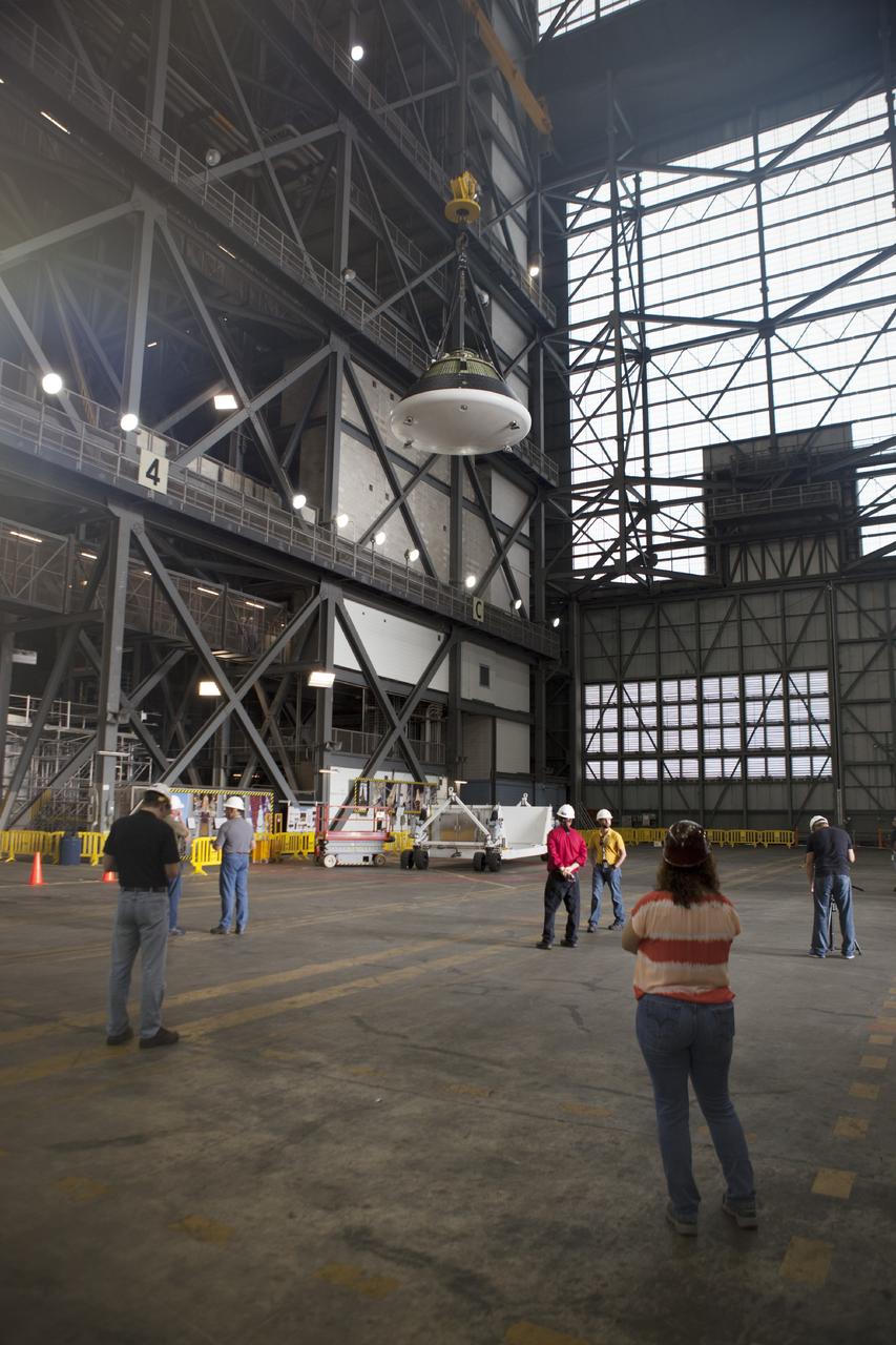 CAPE CANAVERAL, Fla. – At NASA’s Kennedy Space Center in Florida, technicians monitor the progress as the Orion ground test vehicle, or GTA, is lifted by crane in the transfer aisle of the Vehicle Assembly Building. The ground test vehicle is being used for path finding operations, including simulated manufacturing, assembly and stacking procedures. Orion is the exploration spacecraft designed to carry astronauts to destinations not yet explored by humans, including an asteroid and Mars. It will have emergency abort capability, sustain the crew during space travel and provide safe re-entry from deep space return velocities. The first unpiloted test flight of Orion is scheduled to launch in 2014 atop a Delta IV rocket and in 2017 on NASA’s Space Launch System rocket. For more information, visit www.nasa.gov/orion. Photo credit: Dimitri Gerondidakis