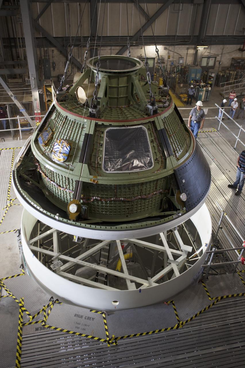 CAPE CANAVERAL, Fla. – At NASA’s Kennedy Space Center in Florida, technicians monitor the progress as the Orion ground test vehicle, or GTA, is being lowered by crane toward a mockup of the service module in high bay 4 of the Vehicle Assembly Building. The ground test vehicle is being used for path finding operations, including simulated manufacturing, assembly and stacking procedures. Orion is the exploration spacecraft designed to carry astronauts to destinations not yet explored by humans, including an asteroid and Mars. It will have emergency abort capability, sustain the crew during space travel and provide safe re-entry from deep space return velocities. The first unpiloted test flight of Orion is scheduled to launch in 2014 atop a Delta IV rocket and in 2017 on NASA’s Space Launch System rocket. For more information, visit www.nasa.gov/orion. Photo credit: Dimitri Gerondidakis