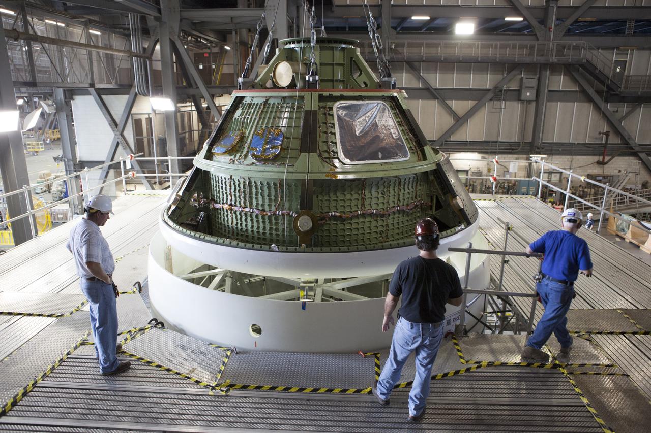 CAPE CANAVERAL, Fla. – At NASA’s Kennedy Space Center in Florida, technicians monitor the progress as the Orion ground test vehicle, or GTA, is lowered by crane toward a mockup of the service module in high bay 4 of the Vehicle Assembly Building. The ground test vehicle is being used for path finding operations, including simulated manufacturing, assembly and stacking procedures. Orion is the exploration spacecraft designed to carry astronauts to destinations not yet explored by humans, including an asteroid and Mars. It will have emergency abort capability, sustain the crew during space travel and provide safe re-entry from deep space return velocities. The first unpiloted test flight of Orion is scheduled to launch in 2014 atop a Delta IV rocket and in 2017 on NASA’s Space Launch System rocket. For more information, visit www.nasa.gov/orion. Photo credit: Dimitri Gerondidakis