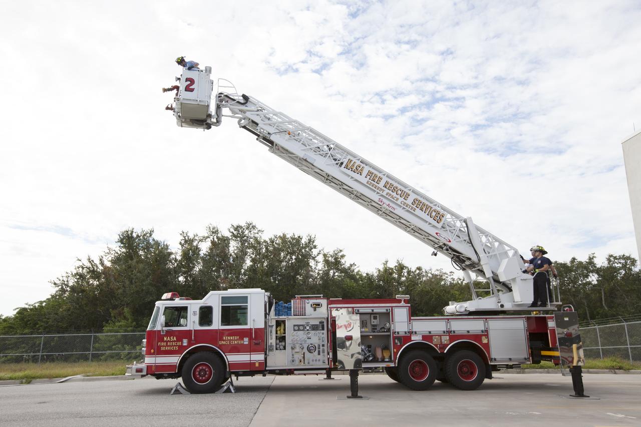 CAPE CANAVERAL, Fla. – At Fire Station No. 2 near the Shuttle Landing Facility at NASA’s Kennedy Space Center in Florida, Fire Rescue Services personnel have deployed the ladder on the aerial fire truck during training in order to be certified in the operation and use of the vehicle.    The center’s Fire Rescue Services recently achieved Pro Board Certification in aerial fire truck operations. Pro Board Certification is a globally recognized certification that puts on multiple courses that all fire departments throughout the world recognize and use to train their personnel. The unique aerial truck contains a 100-foot extendable ladder with a bucket at the end of it that can be used for rescues from taller buildings or aircraft rescue firefighting. Photo credit: NASA/Kim Shiflett