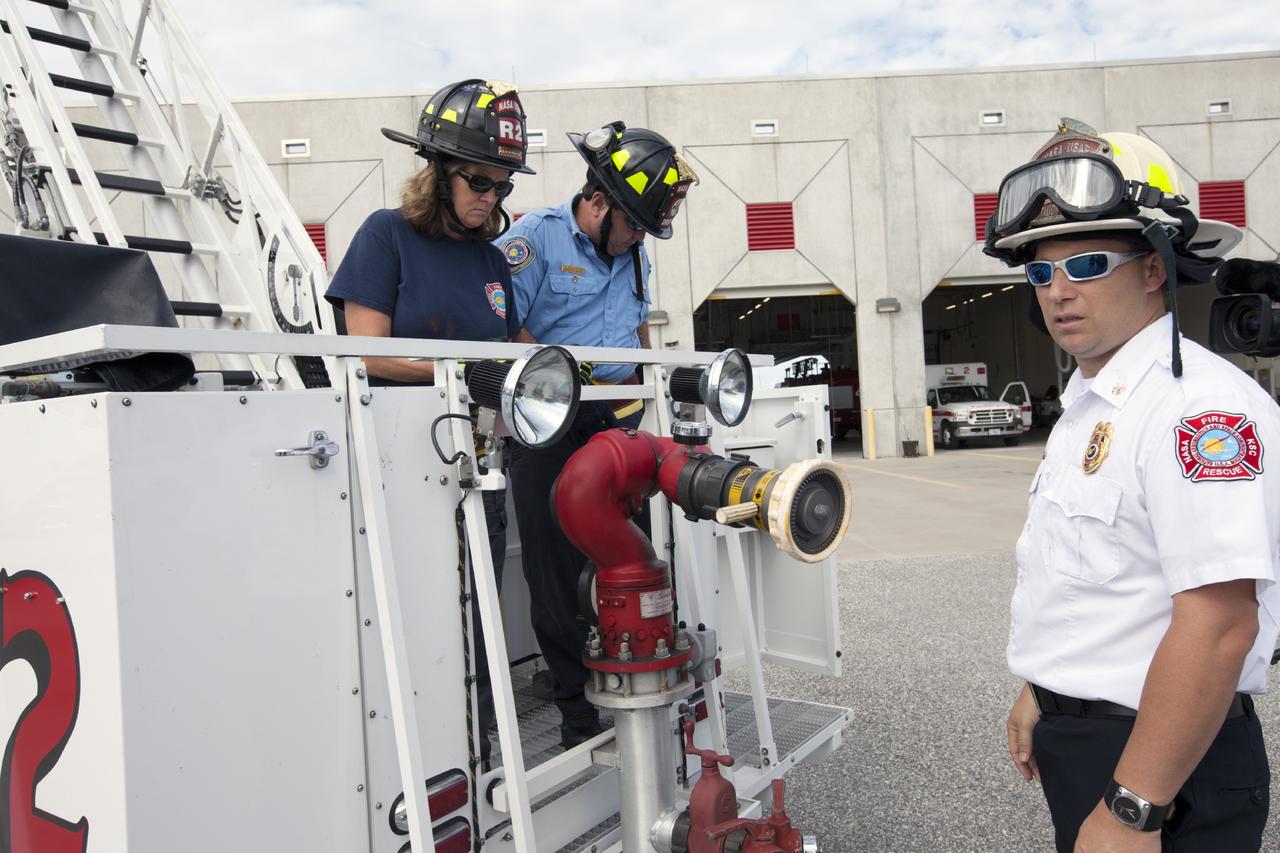 CAPE CANAVERAL, Fla. – At Fire Station No. 2 near the Shuttle Landing Facility at NASA’s Kennedy Space Center in Florida, Mark Huetter, assistant chief of training with the center’s Fire Department, monitors training procedures as two Fire Rescue Services personnel prepare to exit the bucket after training on the aerial fire truck.    The center’s Fire Rescue Services recently achieved Pro Board Certification in aerial fire truck operations. Pro Board Certification is a globally recognized certification that puts on multiple courses that all fire departments throughout the world recognize and use to train their personnel. The unique aerial truck contains a 100-foot extendable ladder with a bucket at the end of it that can be used for rescues from taller buildings or aircraft rescue firefighting. Photo credit: NASA/Kim Shiflett