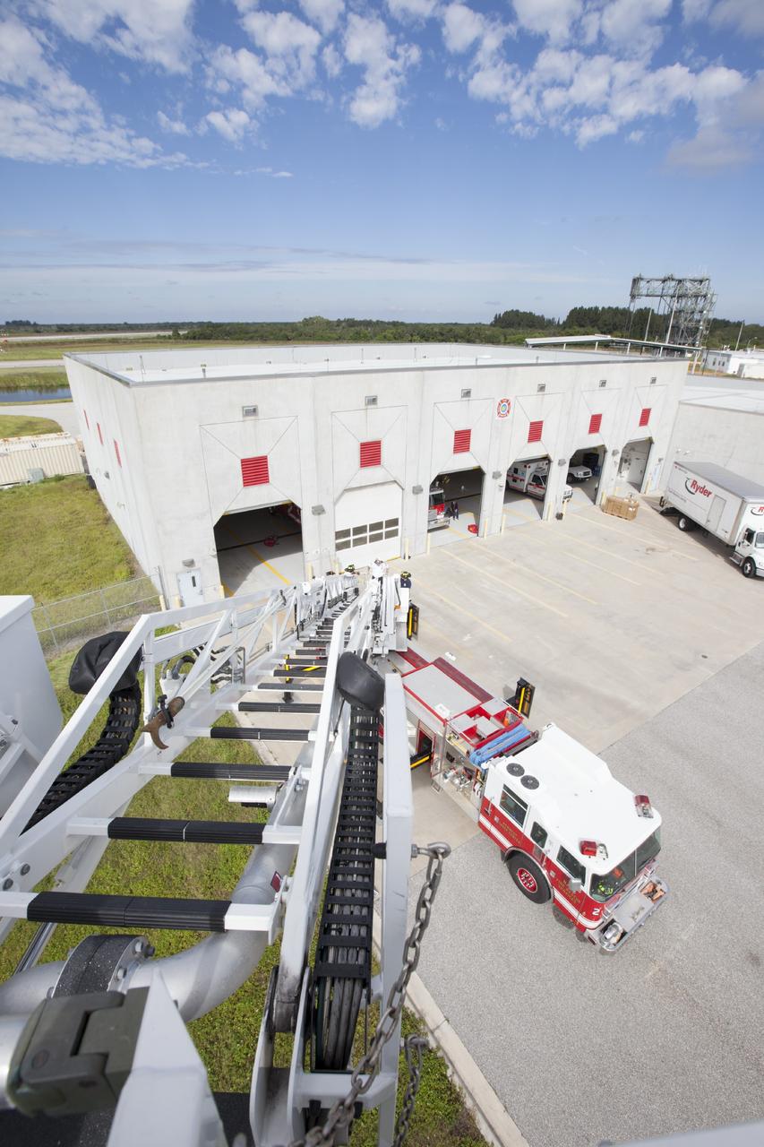 CAPE CANAVERAL, Fla. – At Fire Station No. 2 near the Shuttle Landing Facility at NASA’s Kennedy Space Center in Florida, a bird’s eye view reveals the ladder has been extended on the aerial fire truck during a training exercise.    The center’s Fire Rescue Services recently achieved Pro Board Certification in aerial fire truck operations. Pro Board Certification is a globally recognized certification that puts on multiple courses that all fire departments throughout the world recognize and use to train their personnel. The unique aerial truck contains a 100-foot extendable ladder with a bucket at the end of it that can be used for rescues from taller buildings or aircraft rescue firefighting. Photo credit: NASA/Kim Shiflett