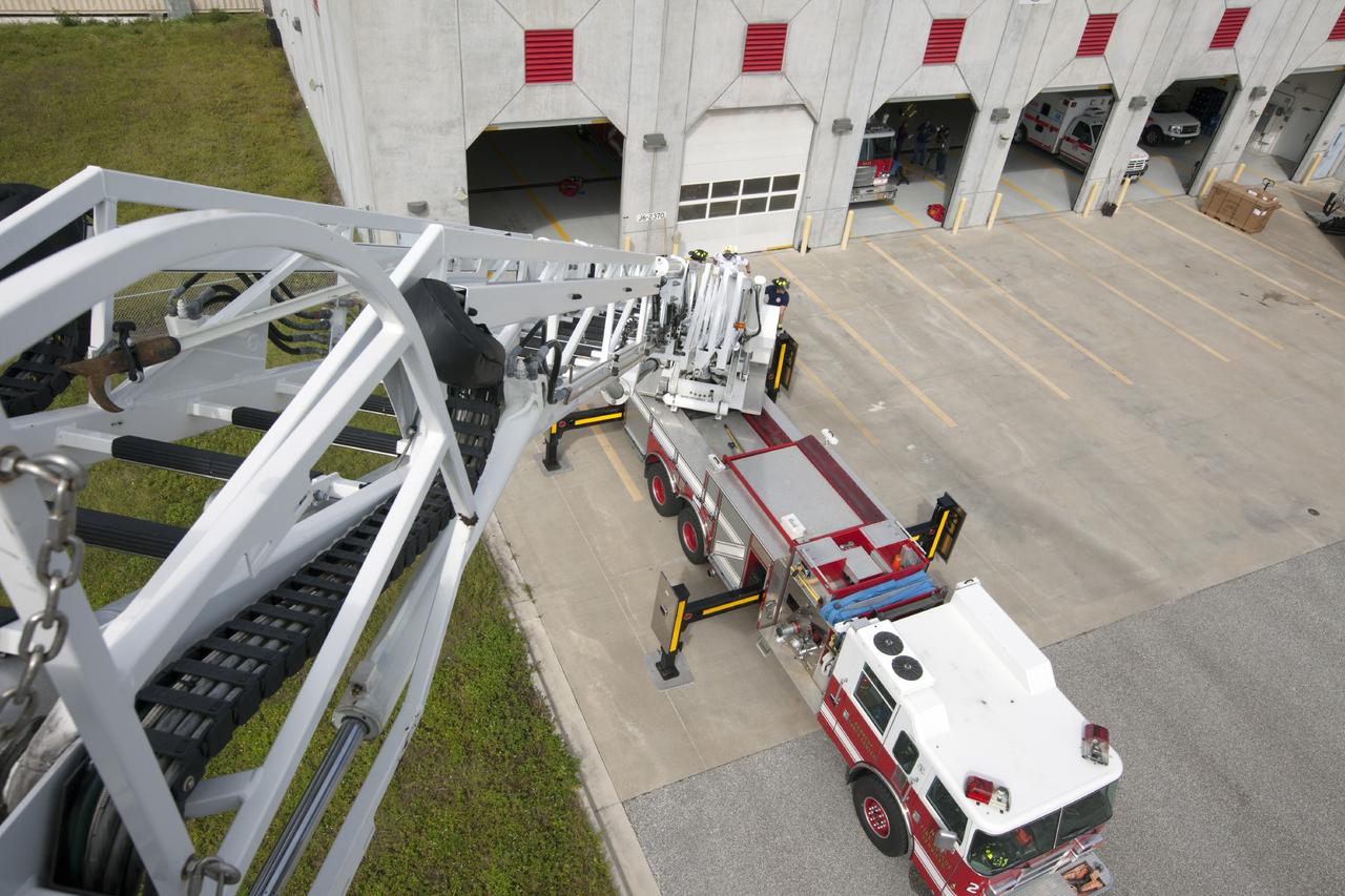 CAPE CANAVERAL, Fla. – At Fire Station No. 2 near the Shuttle Landing Facility at NASA’s Kennedy Space Center in Florida, a bird’s eye view reveals the ladder has been extended on the aerial fire truck during a training exercise.    The center’s Fire Rescue Services recently achieved Pro Board Certification in aerial fire truck operations. Pro Board Certification is a globally recognized certification that puts on multiple courses that all fire departments throughout the world recognize and use to train their personnel. The unique aerial truck contains a 100-foot extendable ladder with a bucket at the end of it that can be used for rescues from taller buildings or aircraft rescue firefighting. Photo credit: NASA/Kim Shiflett