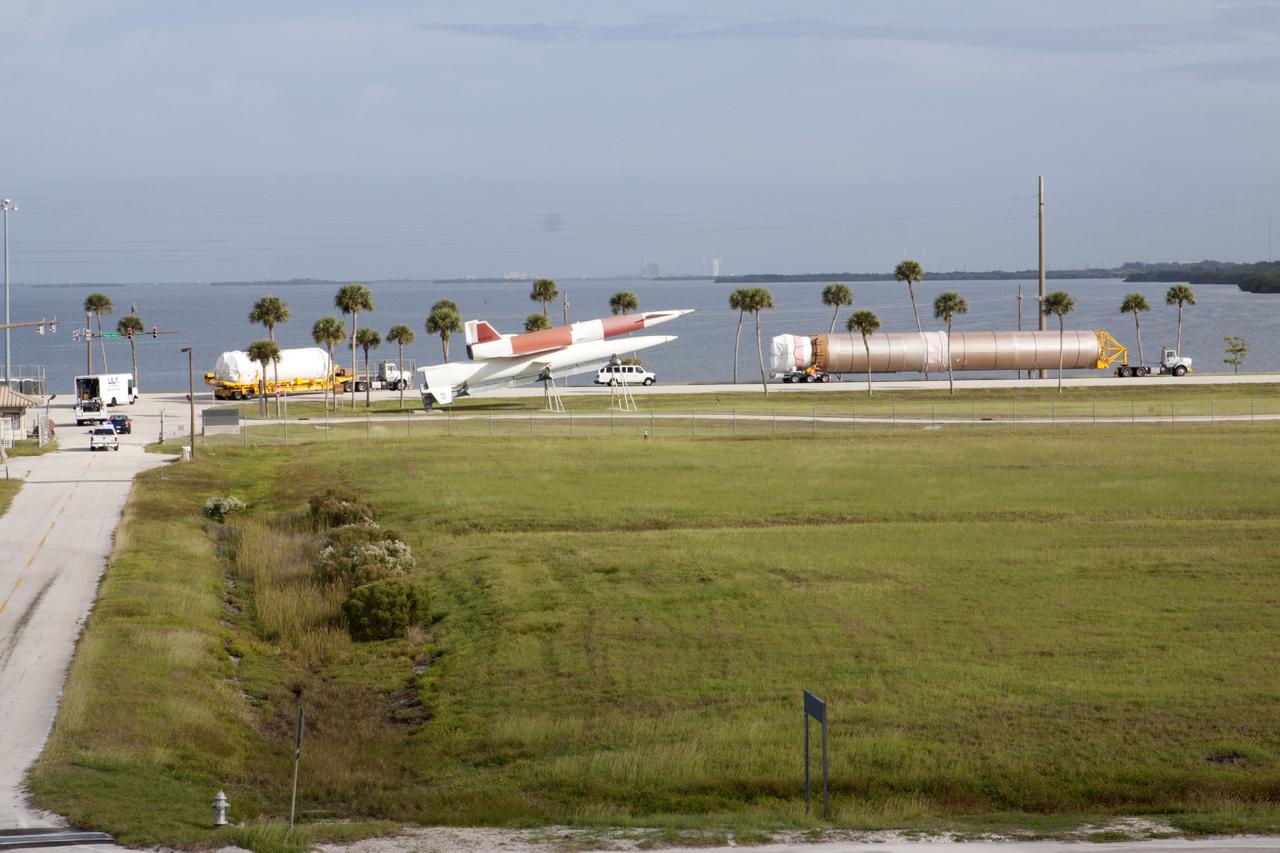 PORT CANAVERAL, Fla. – Following arrival at Port Canaveral, Fla., the United Launch Alliance Atlas V first stage and Centaur upper stage that will boost the Tracking and Data Relay Satellite, or TDRS-L, spacecraft into orbit is being transported to Cape Canaveral Air Force Station's Atlas Spaceflight Operations Center for checkout in preparation for launch. The convoy passes a red and white vintage Navajo rocket displayed near the entrance of Cape Canaveral.      TDRS-L is the second of three next-generation satellites designed to ensure vital operational continuity for the NASA Space Network. It is scheduled to launch from Cape Canaveral's Space Launch Complex 41 atop an Atlas V rocket in January 2014. The current Tracking and Data Relay Satellite system consists of eight in-orbit satellites distributed to provide near continuous information relay service to missions such as the Hubble Space Telescope and International Space Station. For more information, visit: http://www.nasa.gov/content/tracking-and-data-relay-satellite-tdrs/ Photo credit: NASA/ Kim Shiflett