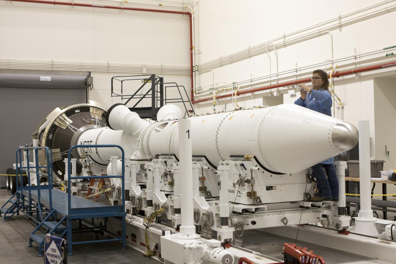 CAPE CANAVERAL, Fla. – Inside the Launch Abort System Facility at NASA’s Kennedy Space Center in Florida, a technician works on the launch abort system, or LAS, for the Orion Exploration Flight Test-1 mission. Horizontally stacked together are the components of the LAS, the launch abort motor, the attitude control motor, the jettison motor and the fairing.    Orion is the exploration spacecraft designed to carry crews to space beyond low Earth orbit. It will provide emergency abort capability, sustain the crew during the space travel and provide safe re-entry from deep space return velocities. The LAS is designed to safely pull the Orion crew module away from the launch vehicle in the event of an emergency on the launch pad or during the initial ascent of NASA’s Space Launch System, or SLS, rocket. Orion’s first unpiloted test flight is scheduled to launch in 2014 atop a Delta IV rocket. A second uncrewed flight test is scheduled for 2017 on the SLS rocket. For more information, visit http://www.nasa.gov/orion. Photo credit: NASA/Jim Grossmann