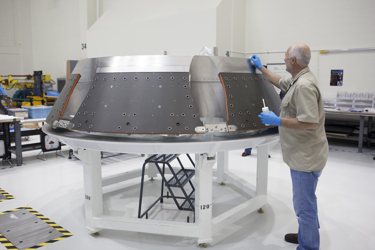 CAPE CANAVERAL, Fla. – Inside the Operations and Checkout Building high bay at NASA’s Kennedy Space Center in Florida, a technician prepares the forward bay cover for the Orion crew module. Orion is the exploration spacecraft designed to carry astronauts to destinations not yet explored by humans, including an asteroid and Mars. It will have emergency abort capability, sustain the crew during space travel and provide safe re-entry from deep space return velocities. The first unpiloted test flight of the Orion is scheduled to launch in 2014 atop a Delta IV rocket and in 2017 on NASA’s Space Launch System rocket. For more information, visit http://www.nasa.gov/orion. Photo credit: NASA/Dimitri Gerondidakis