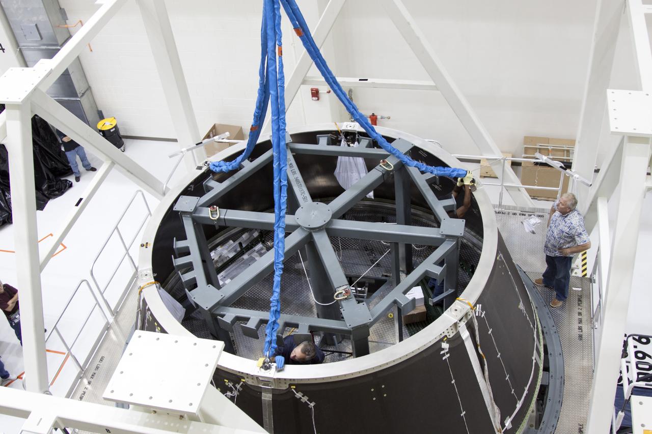 CAPE CANAVERAL, Fla. – Inside the Operations and Checkout Building high bay at NASA’s Kennedy Space Center in Florida, technicians monitor the progress as a crane begins to lift the spacecraft adapter cone for the Orion vehicle from the static load test tool and transfer it to a work stand.     Orion is the exploration spacecraft designed to carry astronauts to destinations not yet explored by humans, including an asteroid and Mars. It will have emergency abort capability, sustain the crew during space travel and provide safe re-entry from deep space return velocities. The first unpiloted test flight of the Orion is scheduled to launch in 2014 atop a Delta IV rocket and in 2017 on NASA’s Space Launch System rocket. For more information, visit http://www.nasa.gov/orion. Photo credit: NASA/Jim Grossmann