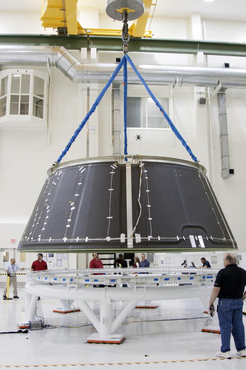 CAPE CANAVERAL, Fla. – Inside the Operations and Checkout Building high bay at NASA’s Kennedy Space Center in Florida, technicians monitor the progress as a crane lowers the spacecraft adapter cone for the Orion vehicle onto a work stand. The adapter cone was transferred from the static load test tool. Orion is the exploration spacecraft designed to carry astronauts to destinations not yet explored by humans, including an asteroid and Mars. It will have emergency abort capability, sustain the crew during space travel and provide safe re-entry from deep space return velocities. The first unpiloted test flight of the Orion is scheduled to launch in 2014 atop a Delta IV rocket and in 2017 on NASA’s Space Launch System rocket. For more information, visit http://www.nasa.gov/orion. Photo credit: NASA/Jim Grossmann