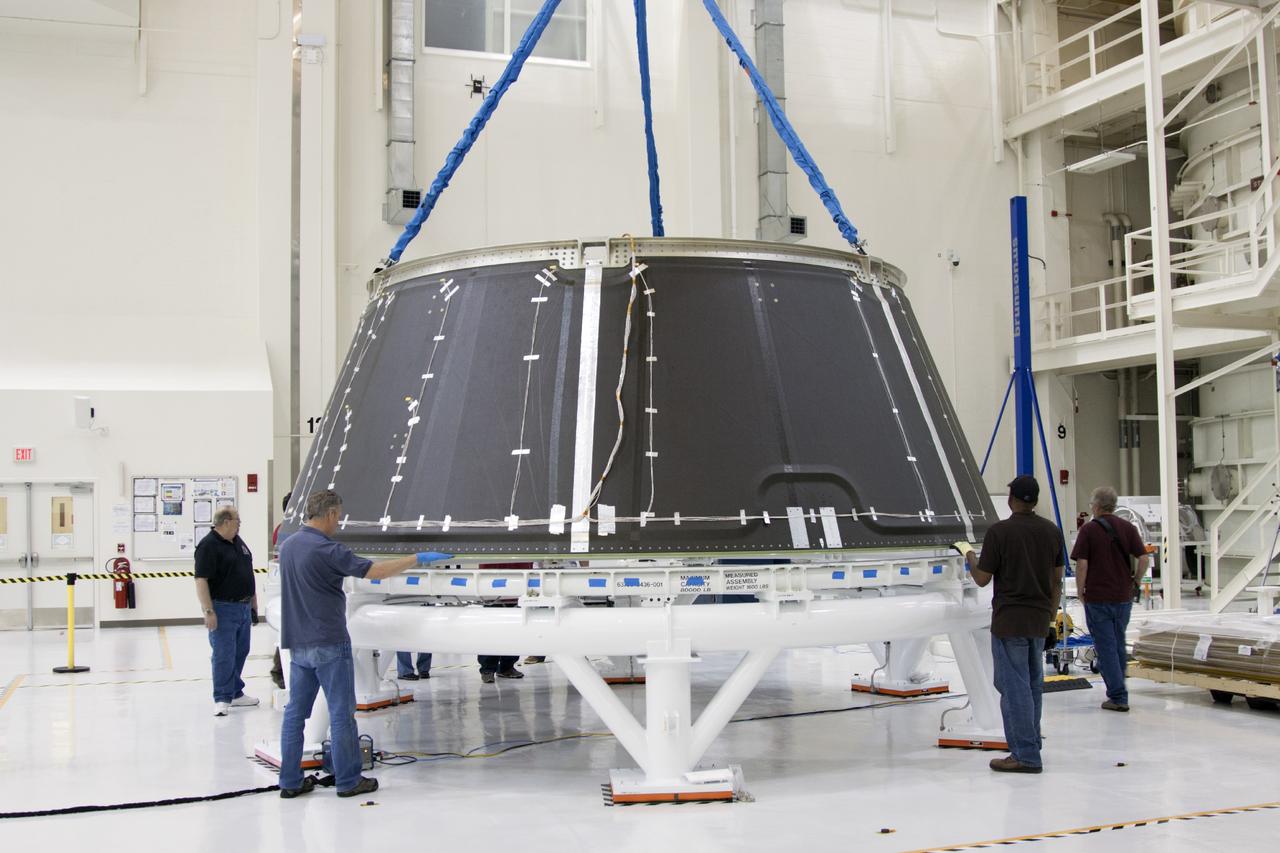 CAPE CANAVERAL, Fla. – Inside the Operations and Checkout Building high bay at NASA’s Kennedy Space Center in Florida, technicians monitor the progress as a crane lowers the spacecraft adapter cone for the Orion vehicle onto a work stand. The adapter cone was transferred from the static load test tool. Orion is the exploration spacecraft designed to carry astronauts to destinations not yet explored by humans, including an asteroid and Mars. It will have emergency abort capability, sustain the crew during space travel and provide safe re-entry from deep space return velocities. The first unpiloted test flight of the Orion is scheduled to launch in 2014 atop a Delta IV rocket and in 2017 on NASA’s Space Launch System rocket. For more information, visit http://www.nasa.gov/orion. Photo credit: NASA/Jim Grossmann
