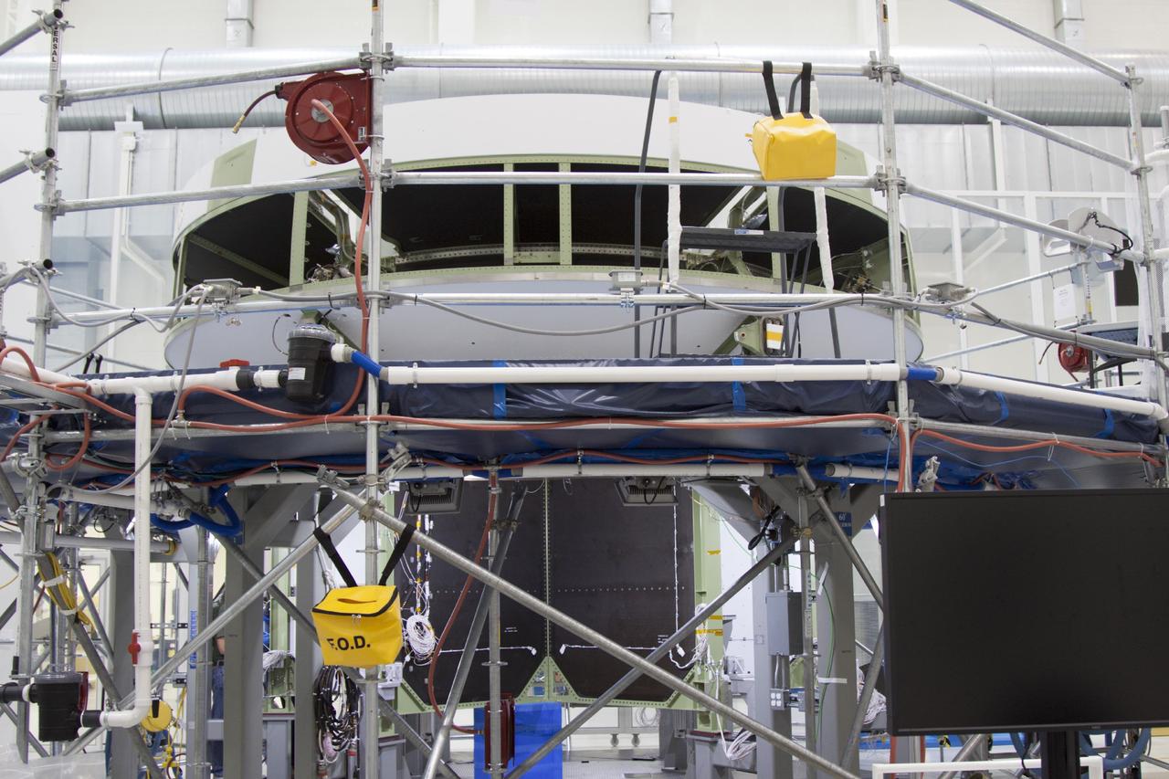 CAPE CANAVERAL, Fla. – Inside the Operations and Checkout Building high bay at NASA’s Kennedy Space Center in Florida, processing work continues on the service module bulkhead for the Orion spacecraft. Technicians have applied shims, drilled fasteners and built up the cable harnesses on the bulkhead.    Orion is the exploration spacecraft designed to carry astronauts to destinations not yet explored by humans, including an asteroid and Mars. It will have emergency abort capability, sustain the crew during space travel and provide safe re-entry from deep space return velocities. The first unpiloted test flight of the Orion is scheduled to launch in 2014 atop a Delta IV rocket and in 2017 on NASA’s Space Launch System rocket. For more information, visit http://www.nasa.gov/orion. Photo credit: NASA/Jim Grossmann