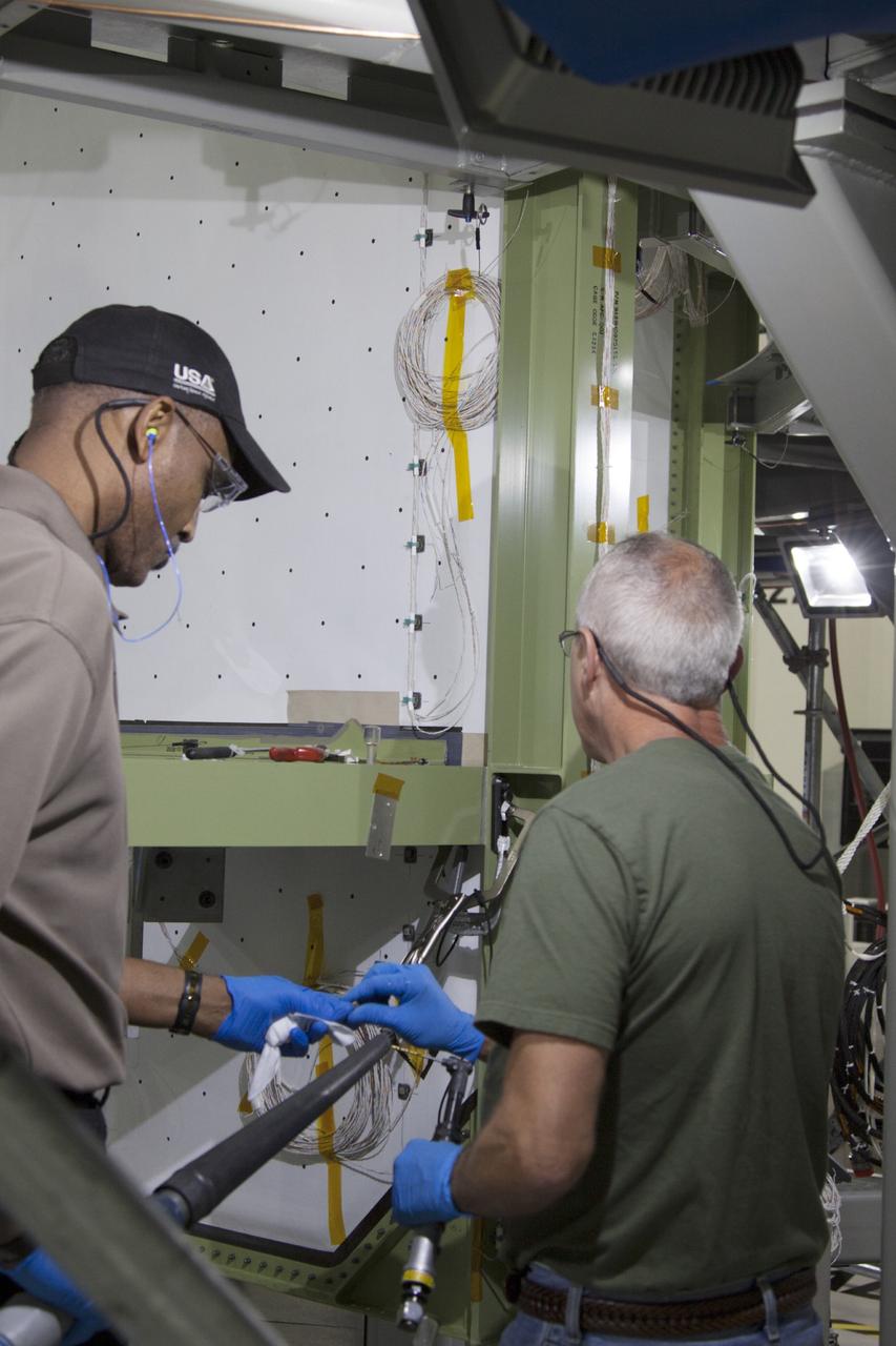CAPE CANAVERAL, Fla. – Inside the Operations and Checkout Building high bay at NASA’s Kennedy Space Center in Florida, technicians work on the service module bulkhead wiring for the Orion spacecraft. Orion is the exploration spacecraft designed to carry astronauts to destinations not yet explored by humans, including an asteroid and Mars. It will have emergency abort capability, sustain the crew during space travel and provide safe re-entry from deep space return velocities. The first unpiloted test flight of the Orion is scheduled to launch in 2014 atop a Delta IV rocket and in 2017 on NASA’s Space Launch System rocket. For more information, visit http://www.nasa.gov/orion. Photo credit: NASA/Jim Grossmann