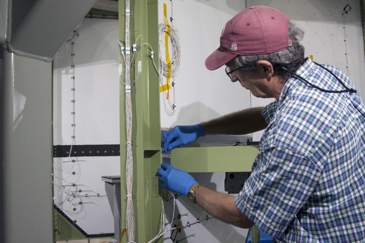 CAPE CANAVERAL, Fla. – Inside the Operations and Checkout Building high bay at NASA’s Kennedy Space Center in Florida, a technician works on the service module bulkhead wiring for the Orion spacecraft.     Orion is the exploration spacecraft designed to carry astronauts to destinations not yet explored by humans, including an asteroid and Mars. It will have emergency abort capability, sustain the crew during space travel and provide safe re-entry from deep space return velocities. The first unpiloted test flight of the Orion is scheduled to launch in 2014 atop a Delta IV rocket and in 2017 on NASA’s Space Launch System rocket. For more information, visit http://www.nasa.gov/orion. Photo credit: NASA/Jim Grossmann