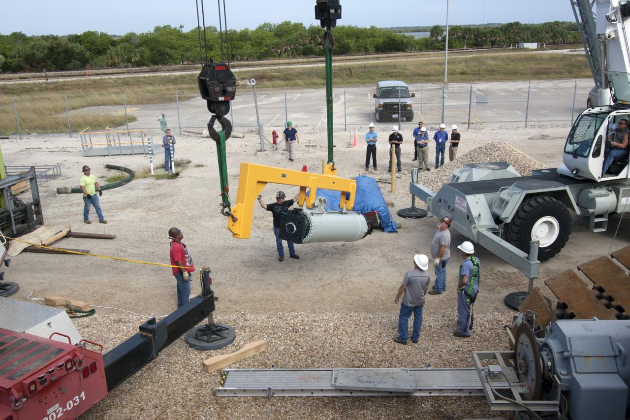 CAPE CANAVERAL, Fla. – Ground support equipment technicians monitor the progress as a crane is used to lift a new jacking, equalizing and leveling, or JEL, hydraulic cylinder for installation on crawler-transporter 1 at the crawler transporter maintenance facility at NASA’s Kennedy Space Center in Florida. New JEL hydraulic cylinders will be installed on CT-1 to test them for increased load carrying capacity and reliability. The Ground Systems Development and Operations Program at Kennedy continues to upgrade CT-1 as part of its general maintenance. CT-1 could be available to carry a variety of launch vehicles to the launch pad. Two crawler-transporters were used to carry the mobile launcher platform and space shuttle to Launch Complex 39 for space shuttle launches for 30 years. Photo credit: NASA/Jim Grossmann